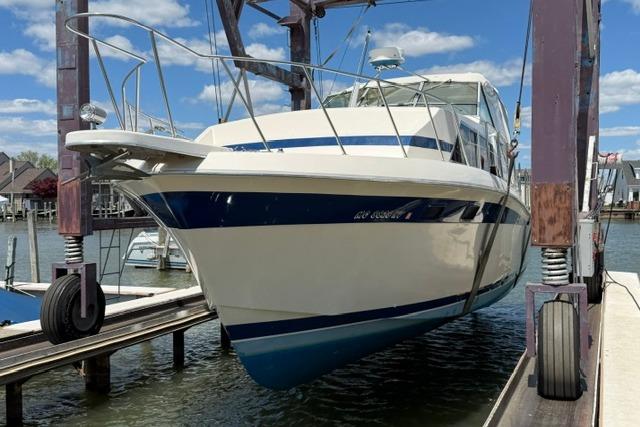 1980 Chris-Craft 381 Catalina yacht on lift, dockside, under blue sky.