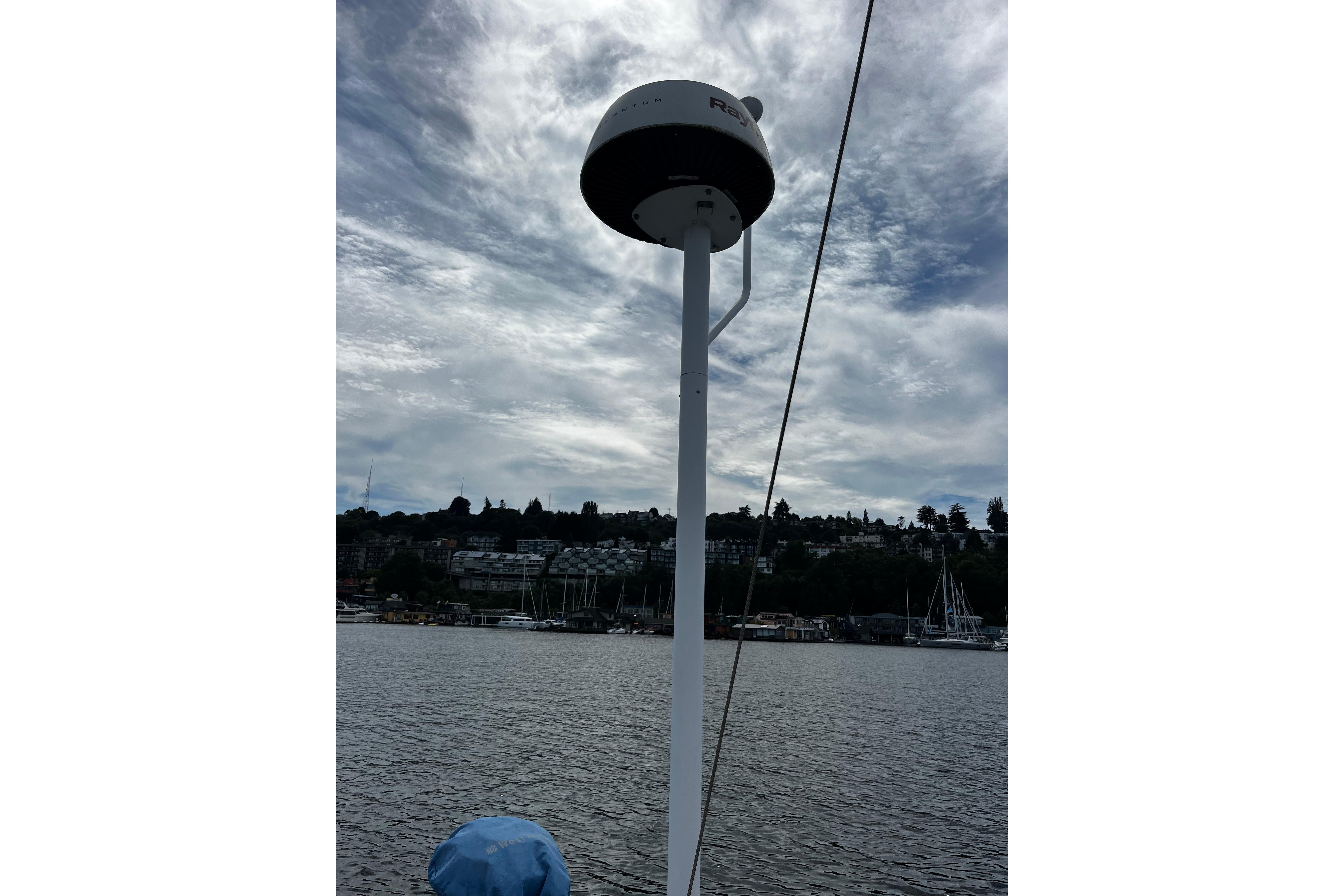 Antenna on 2004 Hanse 411 sailboat against cloudy sky and waterfront view.
