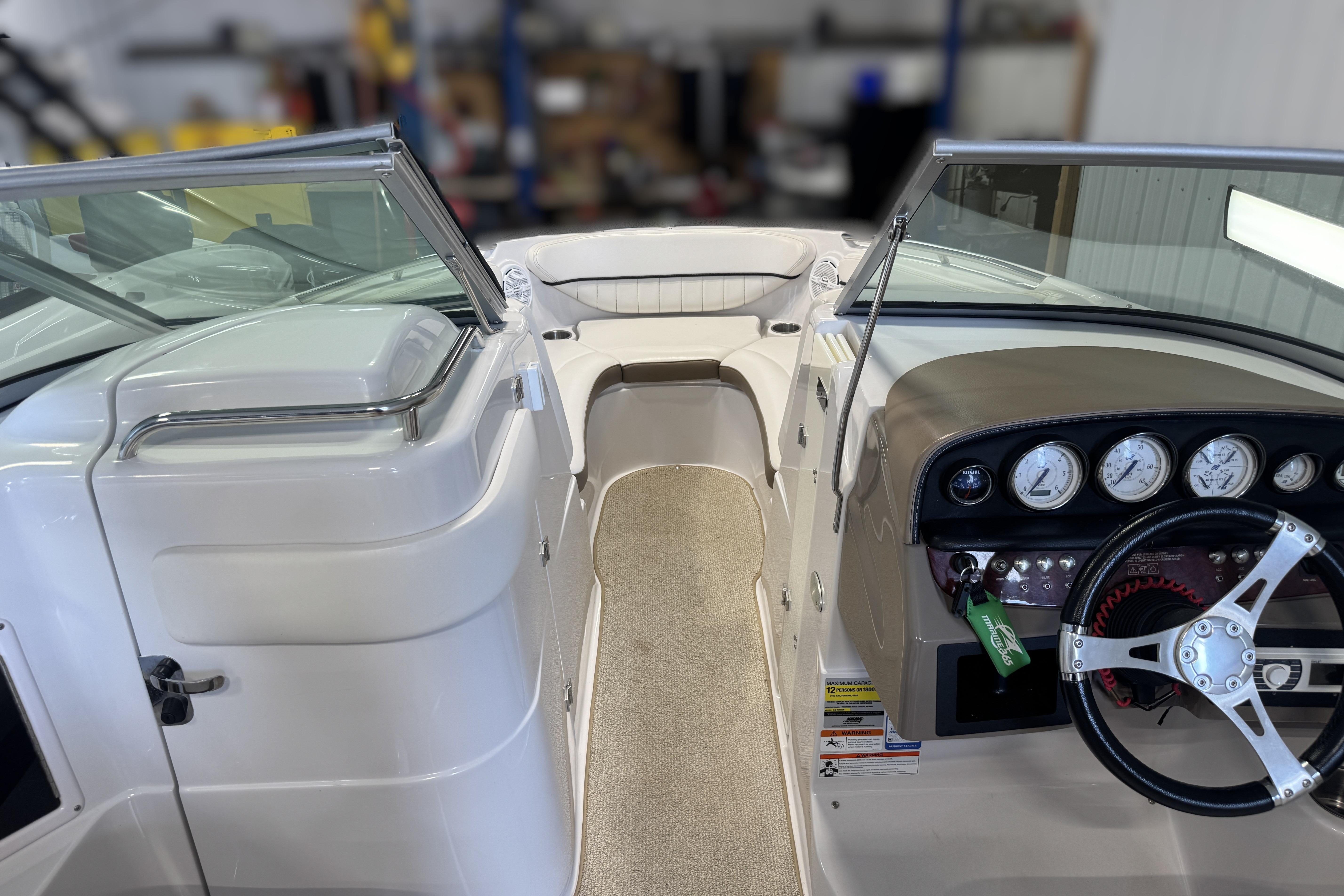 2008 Four Winns H240 boat interior with steering wheel and dashboard gauges.