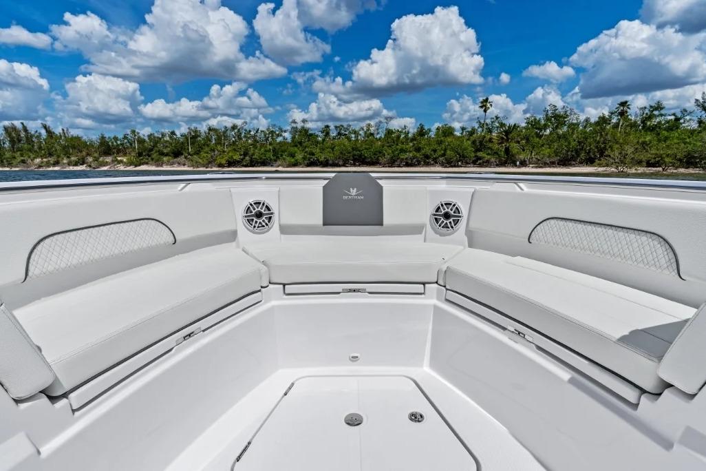 Manufacturer Provided Image: 2026 Bertram 34 CC boat interior with white seating, speakers, and scenic background.