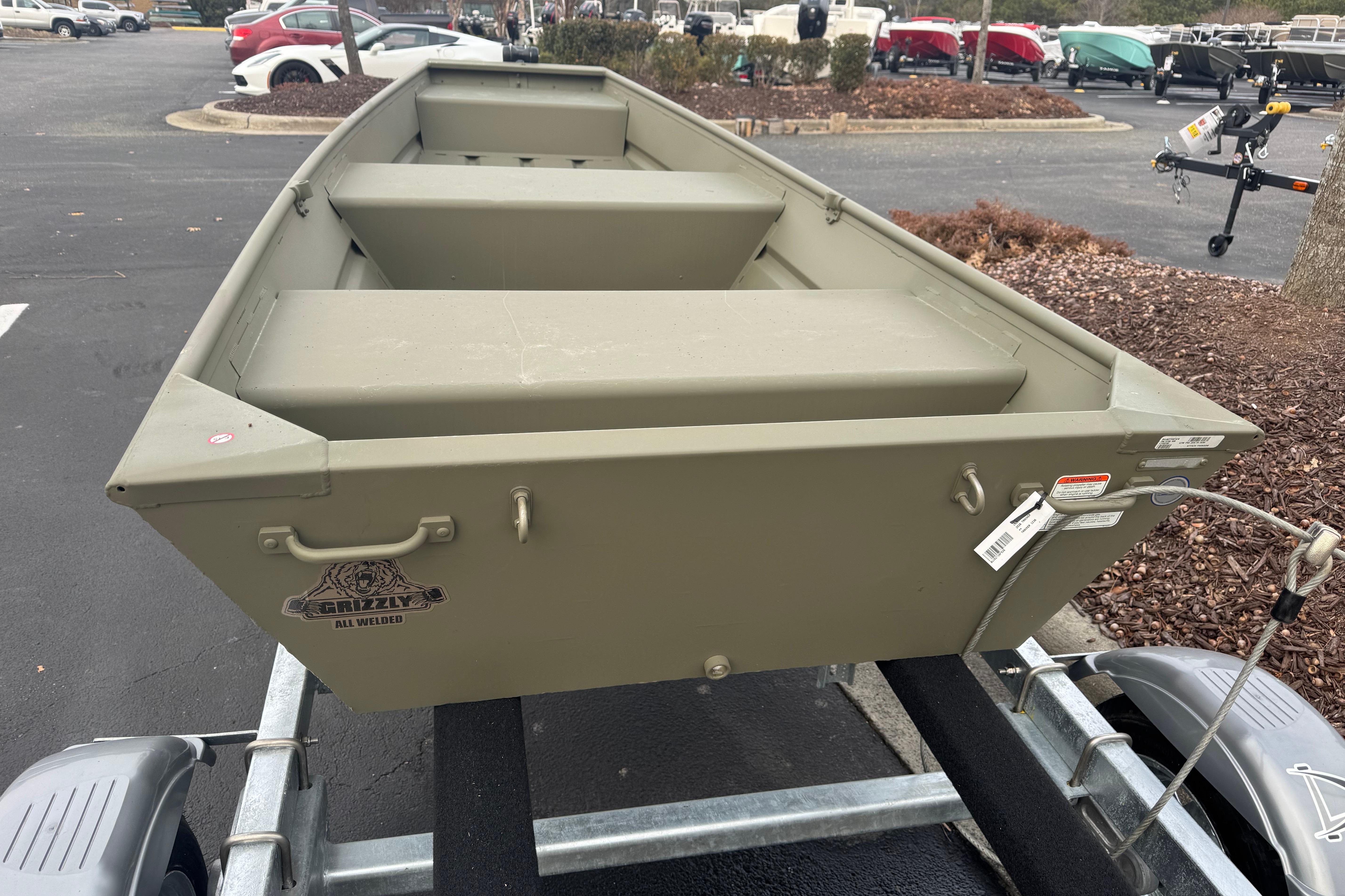 2026 Tracker Grizzly 12 Jon boat on trailer in parking lot.
