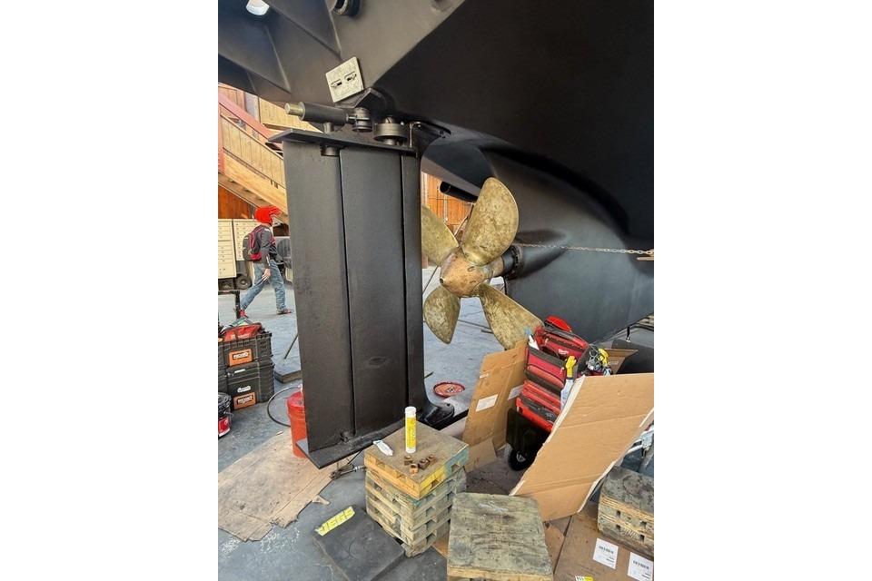 Propeller and rudder of a 1990 Seaton Long Range Cruiser in a workshop setting.