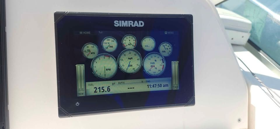 A Simrad display on a boat shows various gauges and information.