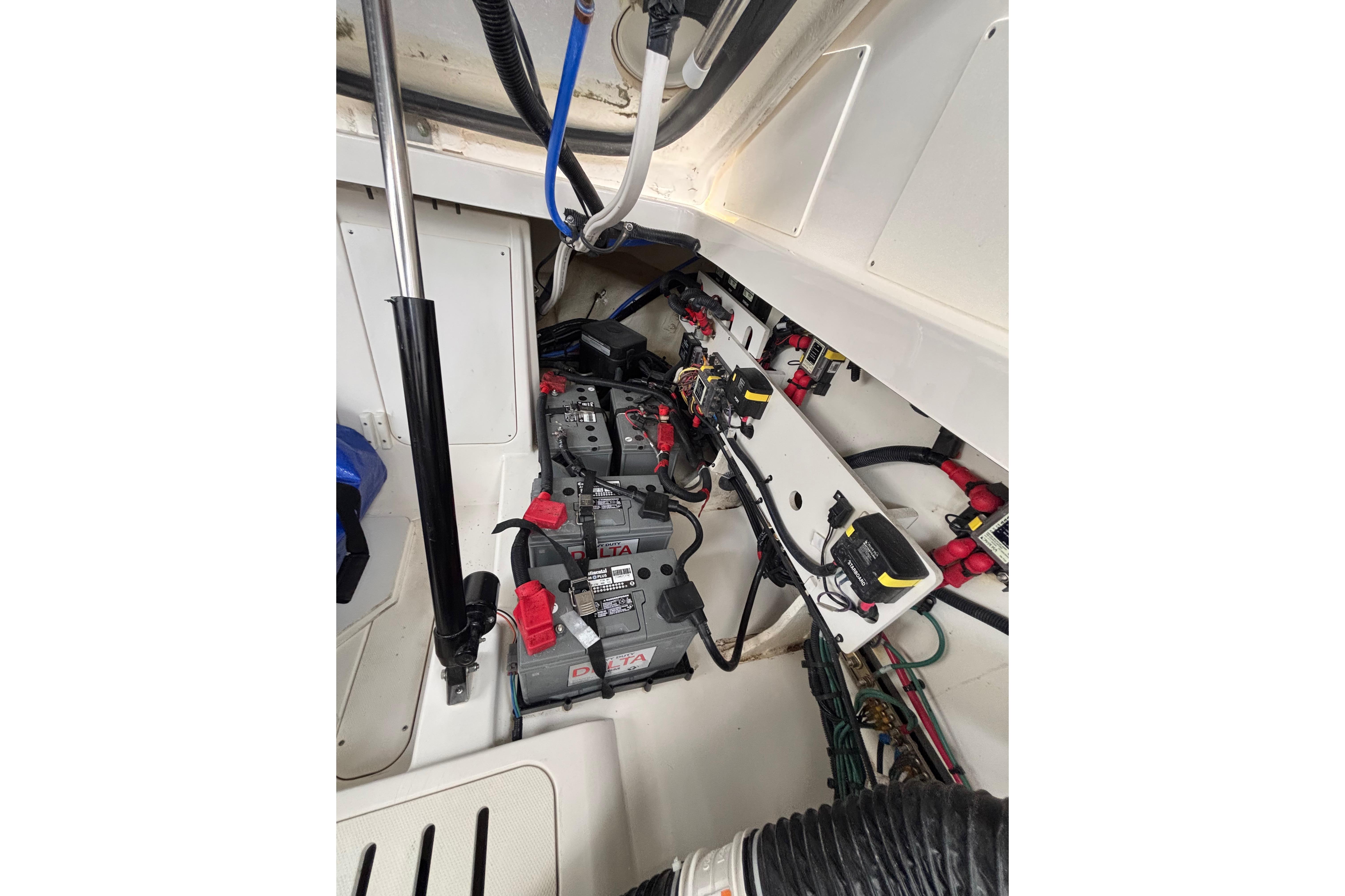 Engine compartment of 2021 Sea Ray Sundancer 320 Outboard with visible batteries and wiring.