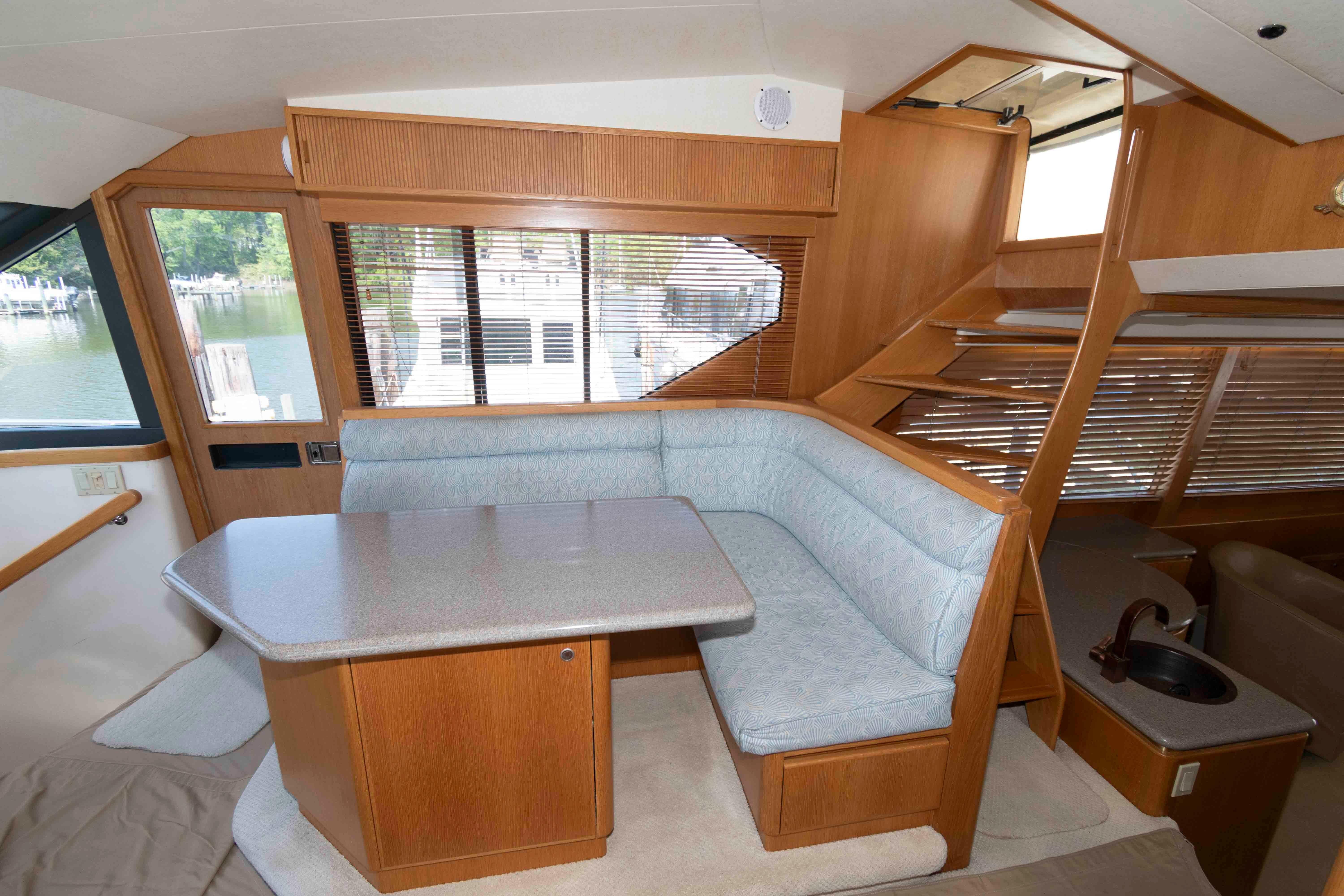 Interior of 1999 West Bay 58 Sonship Pilothouse MY with dining area and staircase.