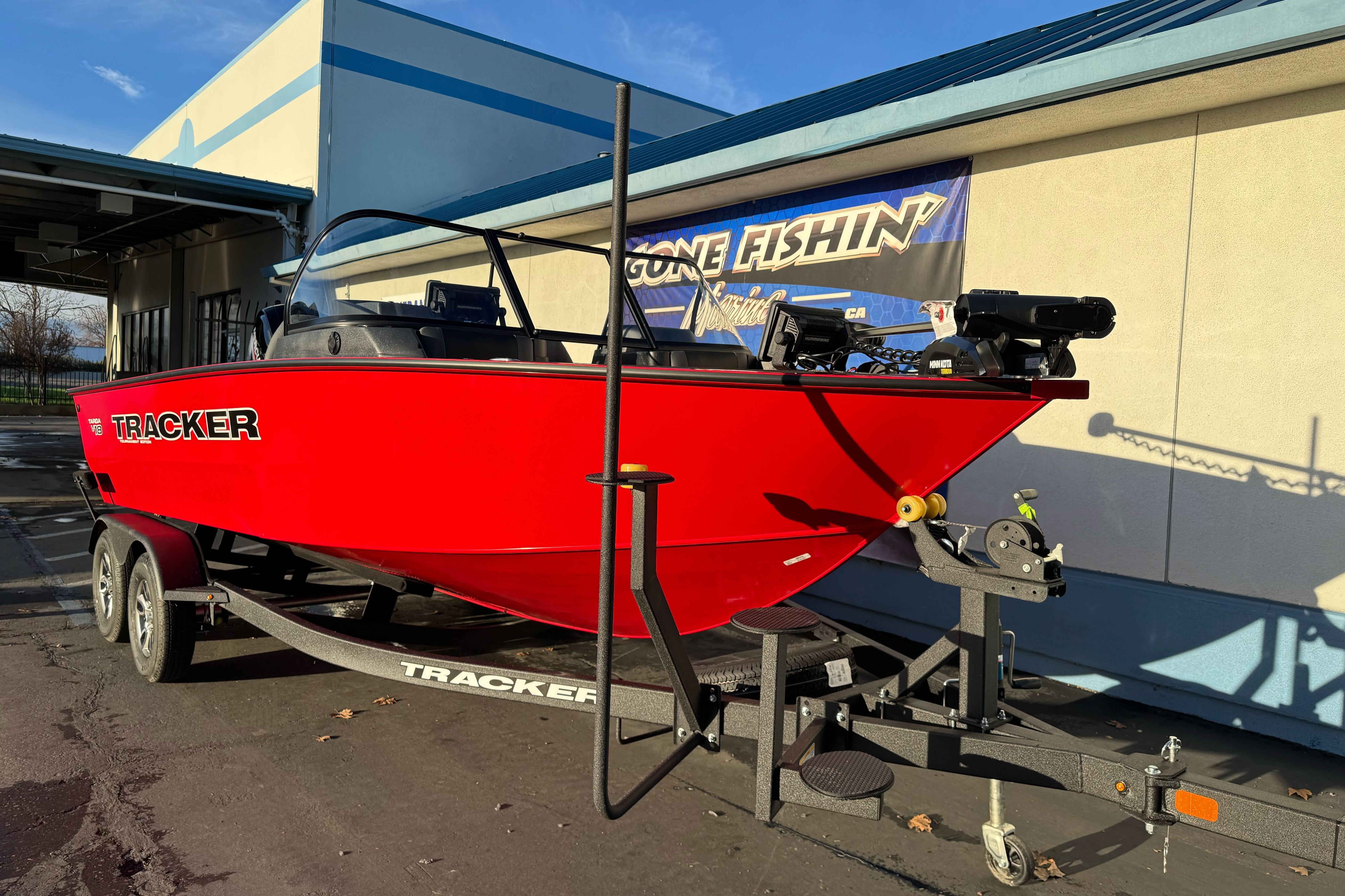 2026 Tracker Targa V-18 WT boat in vibrant red on a trailer, parked outdoors.
