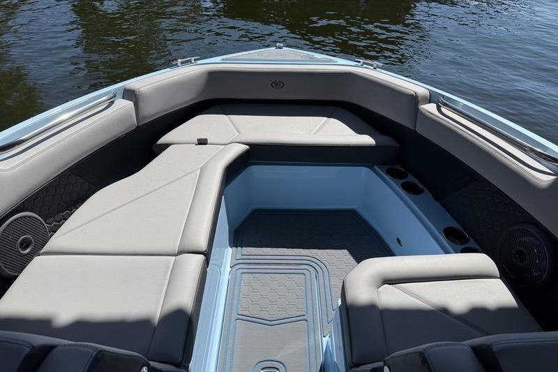 2026 Cobalt R8 Surf boat interior with gray seating and cup holders on calm water.