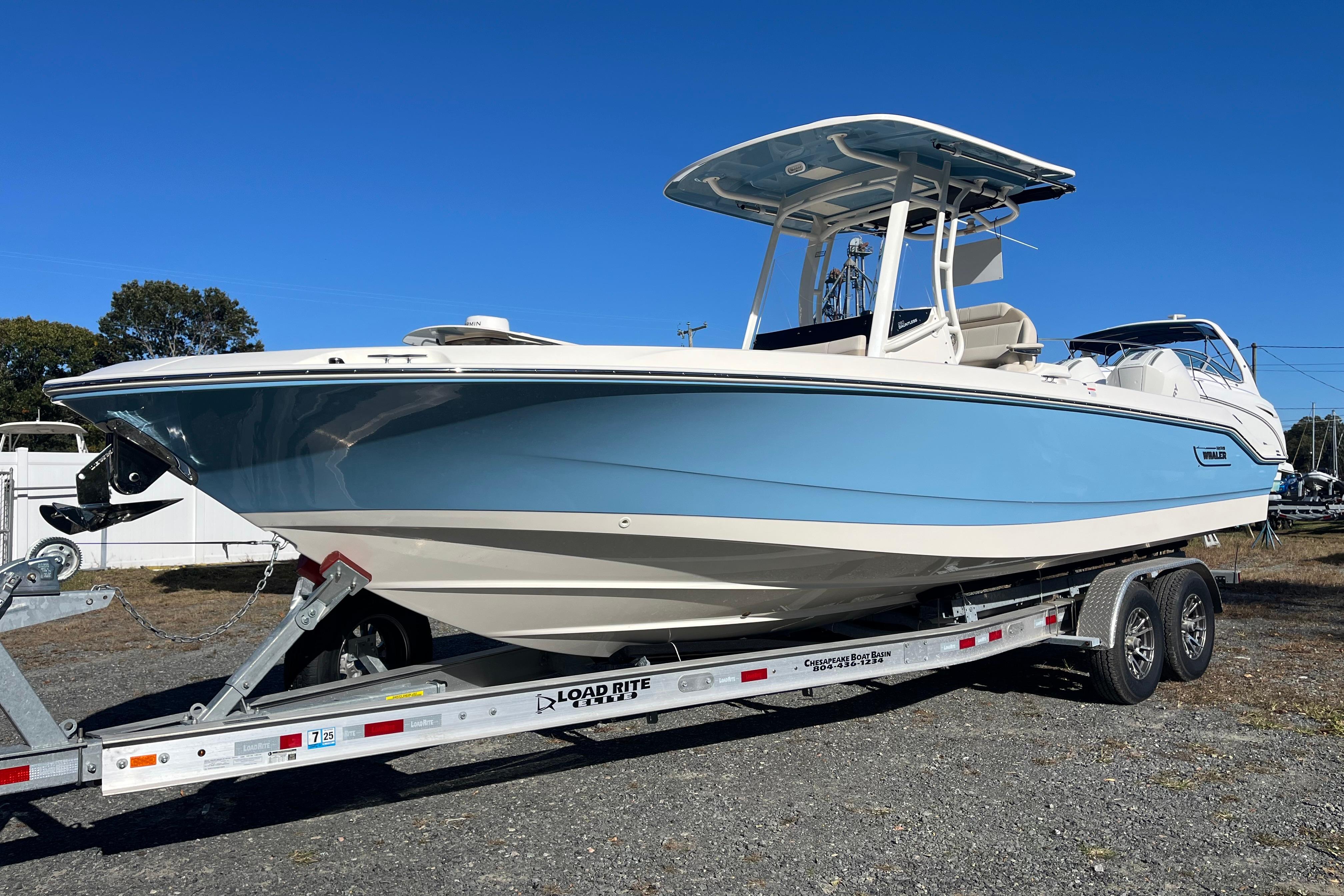 2026 Boston Whaler 280 Dauntless boat on trailer, light blue hull, sunny day.