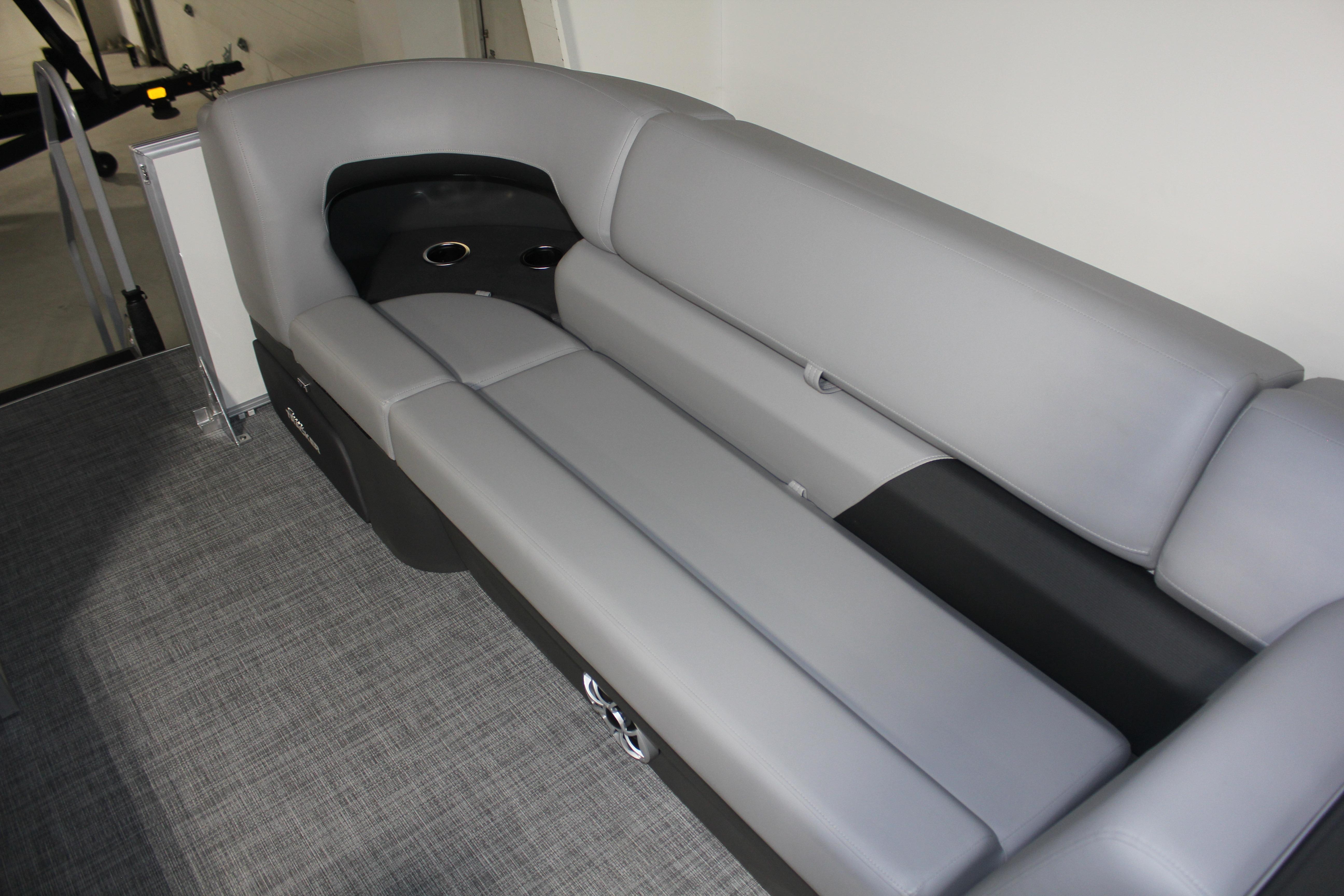 2026 Sun Tracker Party Barge 22 DLX interior with gray seating and cup holders.