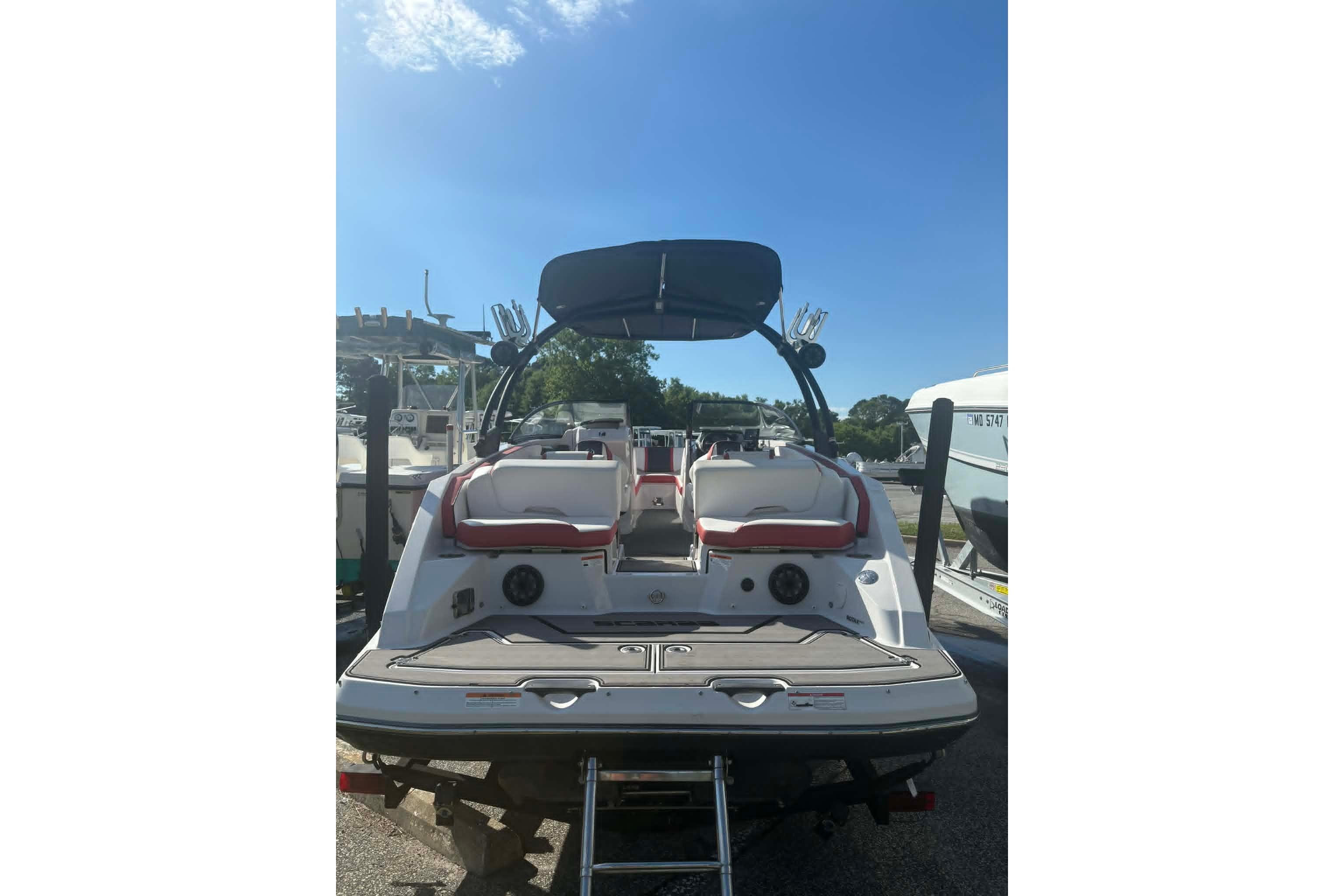 2016 Scarab 255 H.O. Impulse boat, rear view, docked under clear blue sky.