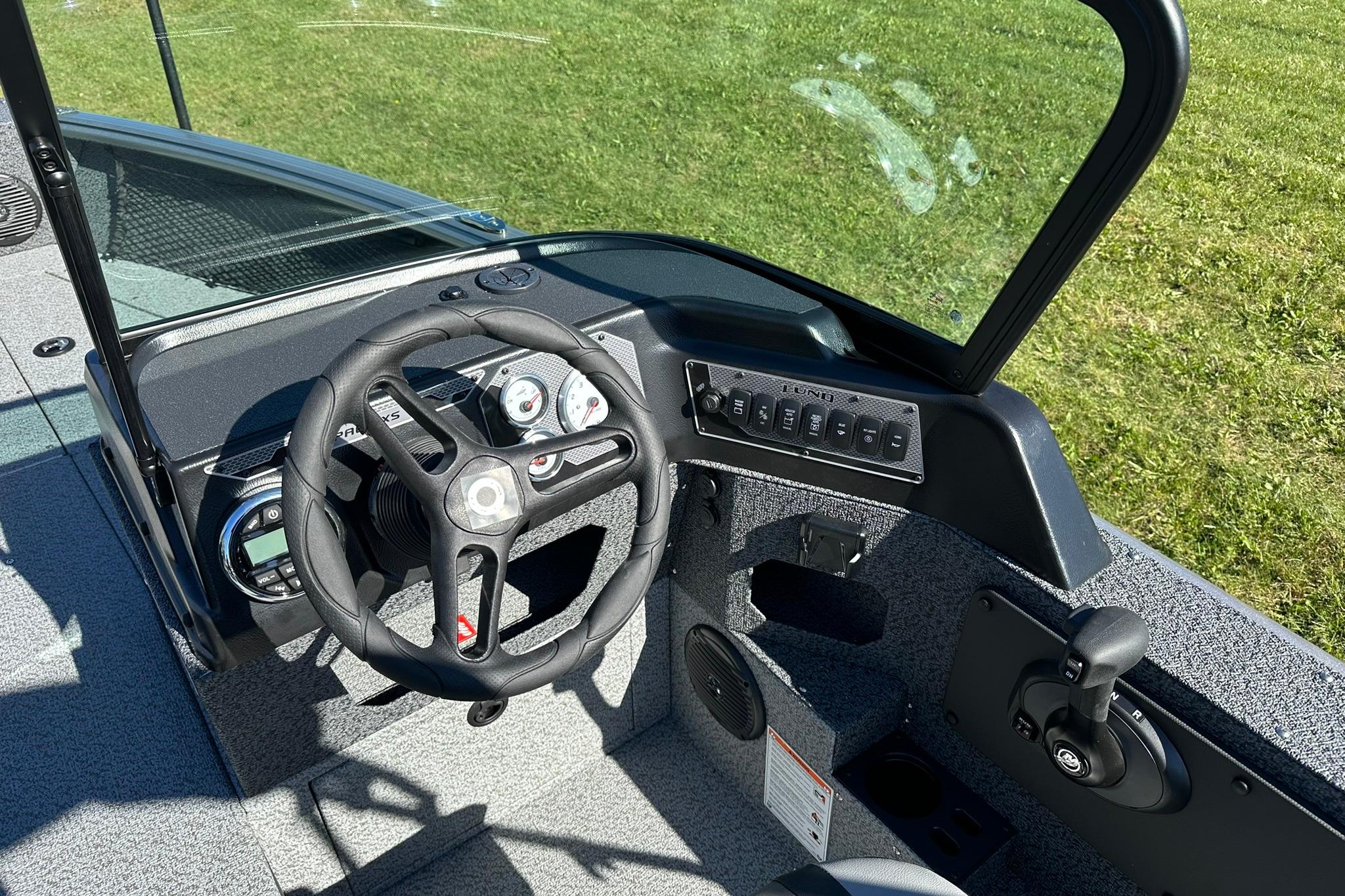 2026 Lund 1875 Impact XS Sport boat dashboard with steering wheel and controls.