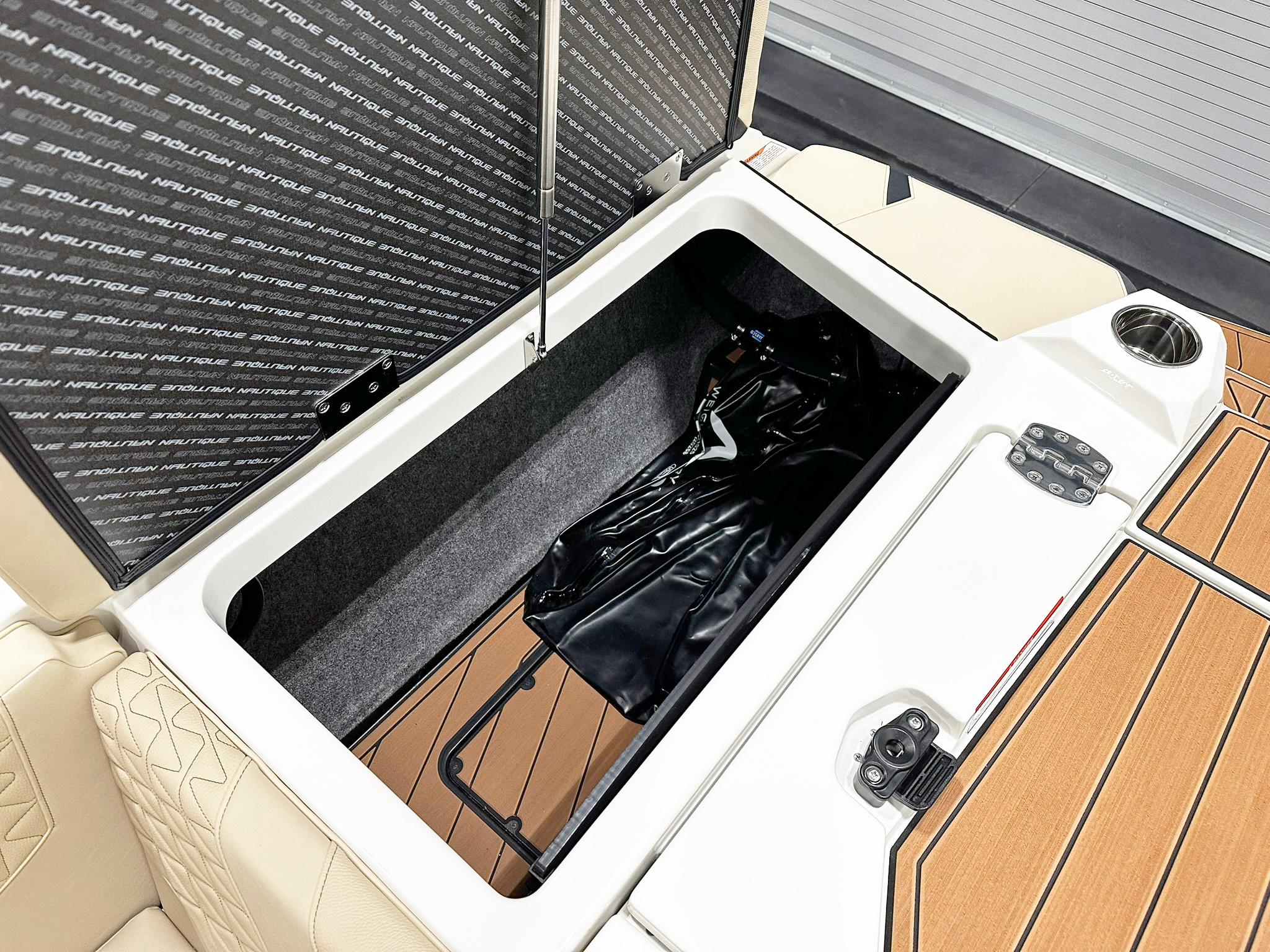 2026 Nautique GS24 boat storage compartment with open lid, showcasing interior space and design.