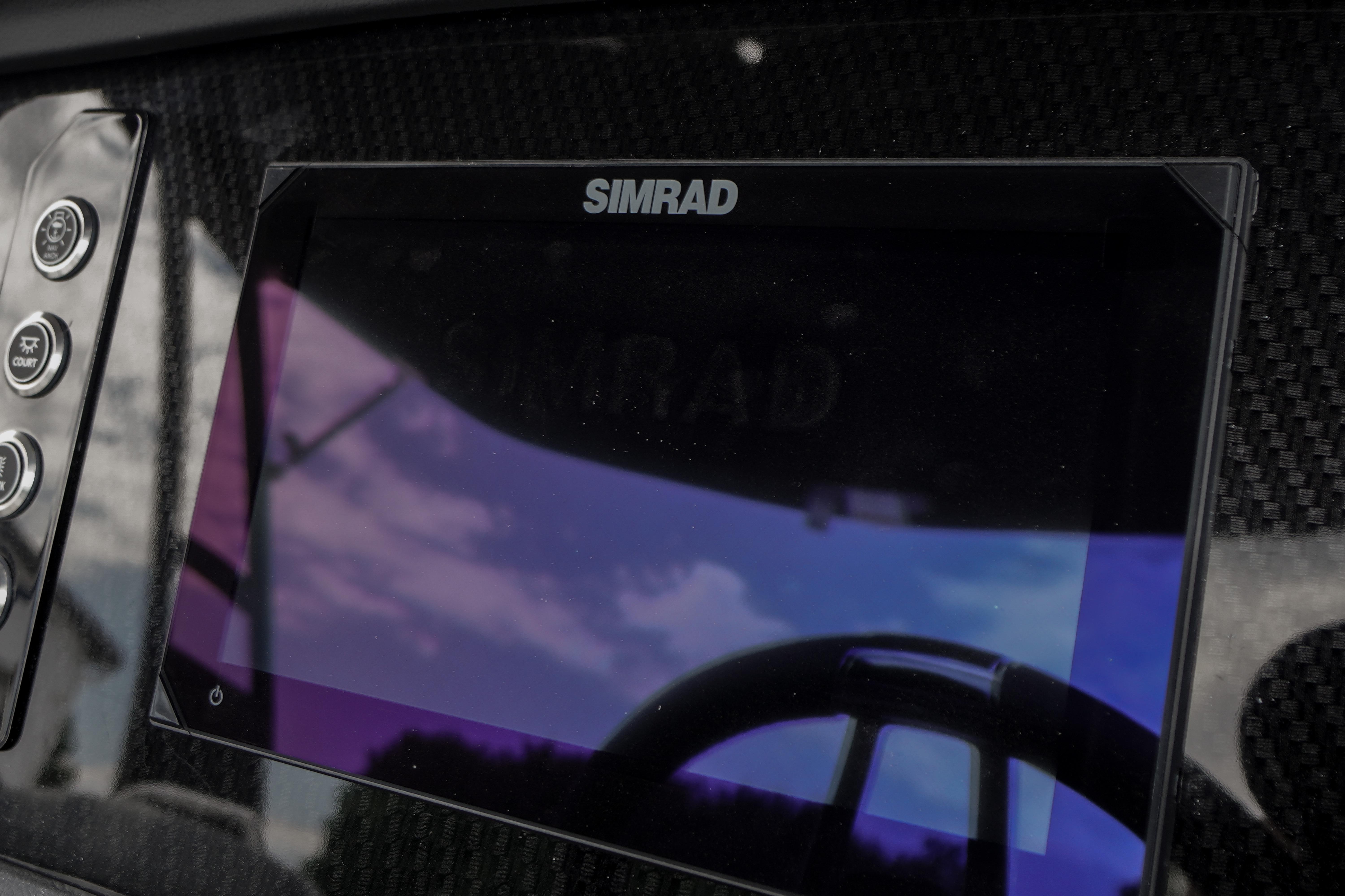 Simrad display on 2026 Chaparral SSX 4 boat dashboard, reflecting sky and surroundings.