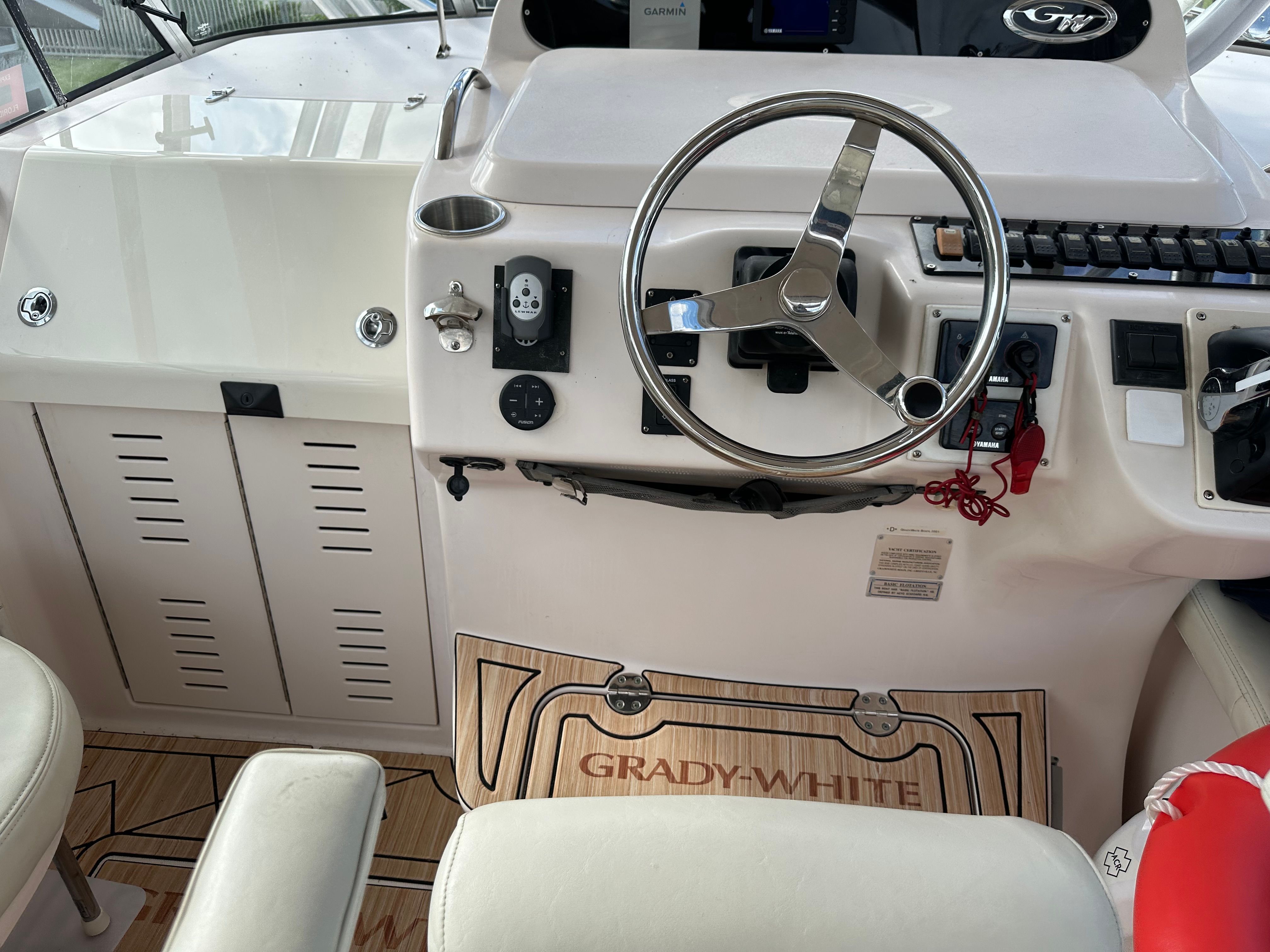 The cockpit of a 2003 Grady-White Express 330 with a sleek steering wheel and instruments.