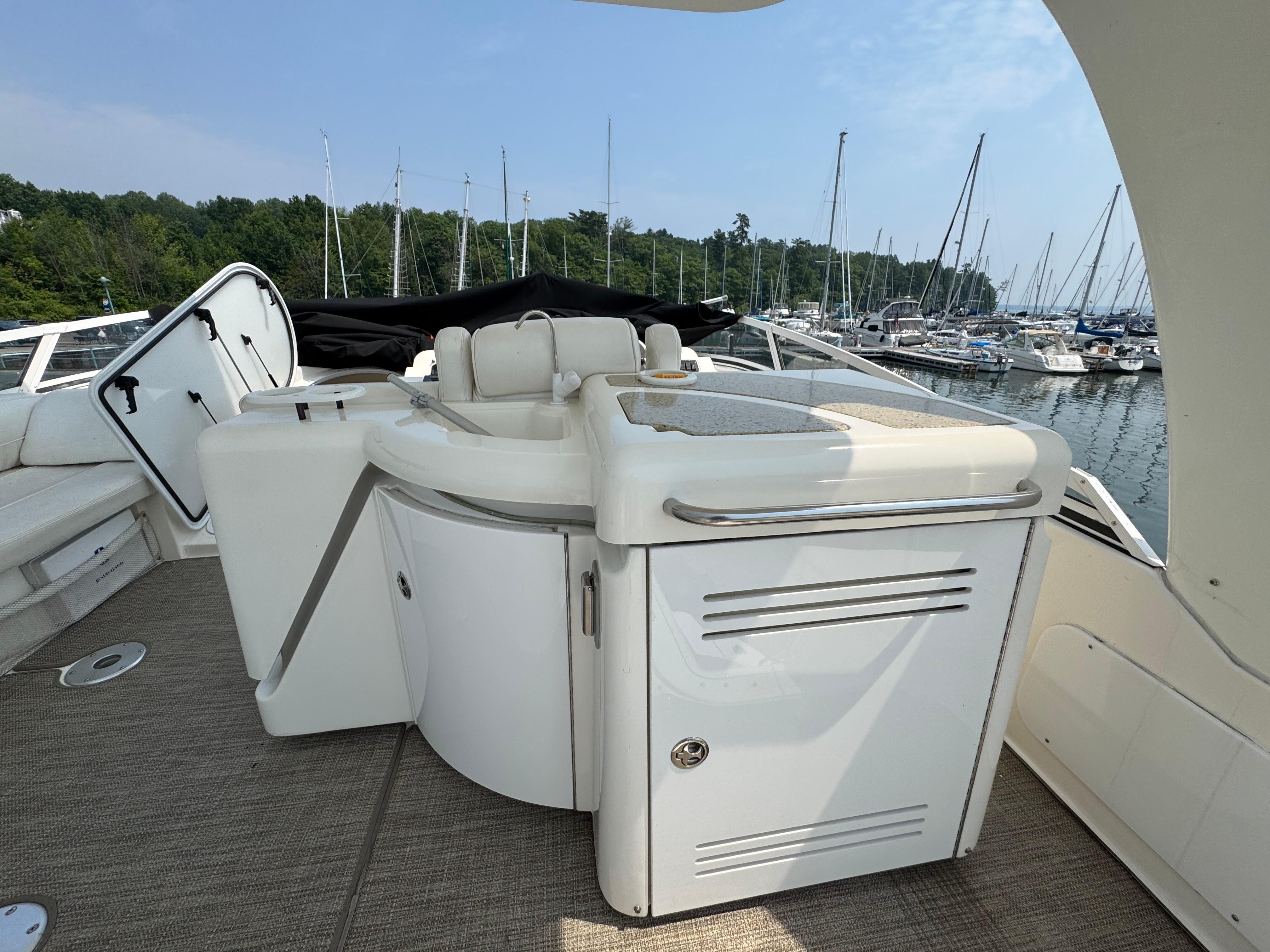 2003 Cruisers Yachts 5000 Sedan Sport deck with seating, docked at marina.