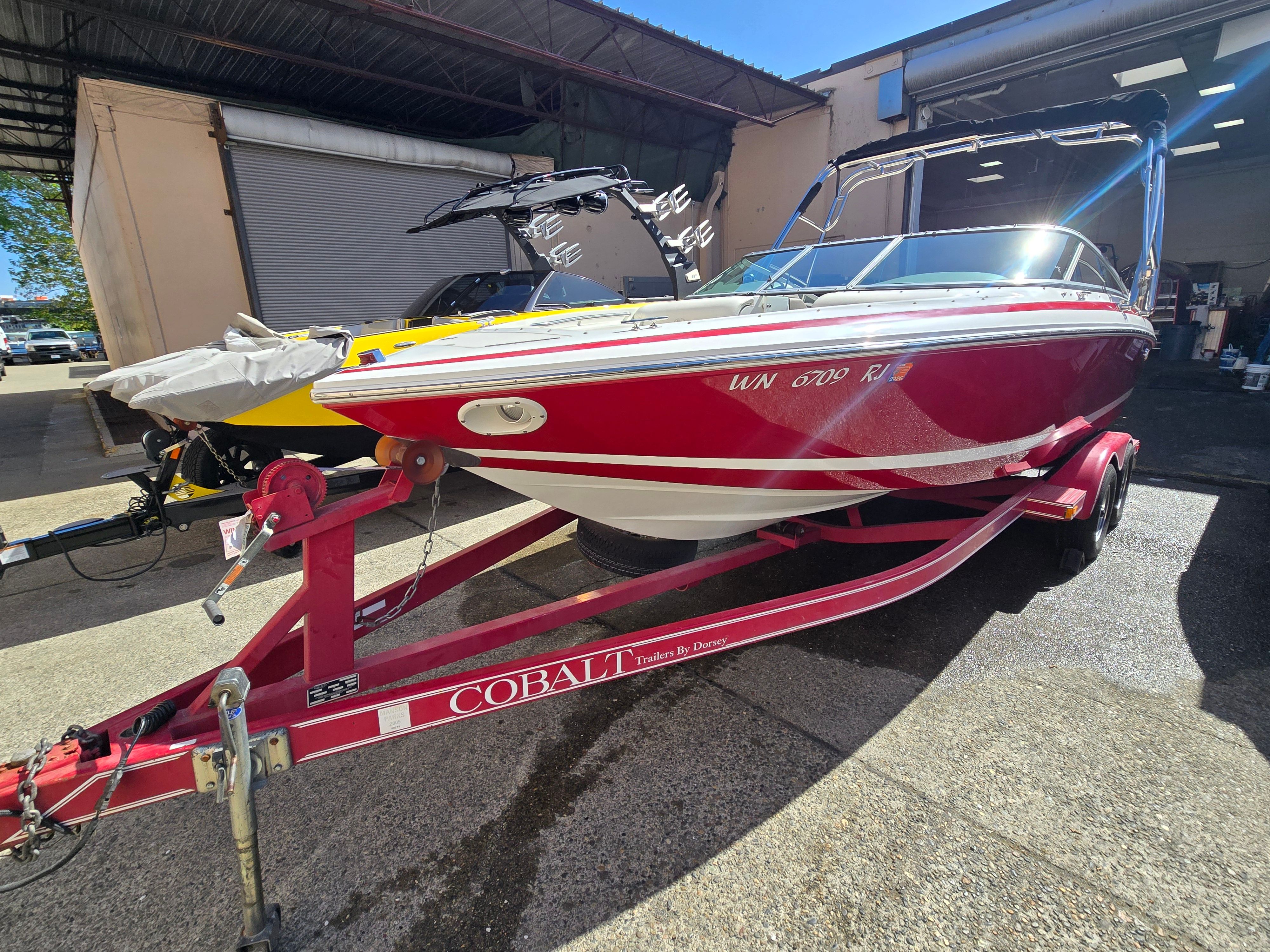 Red 2001 Cobalt 226 boat on trailer in warehouse.