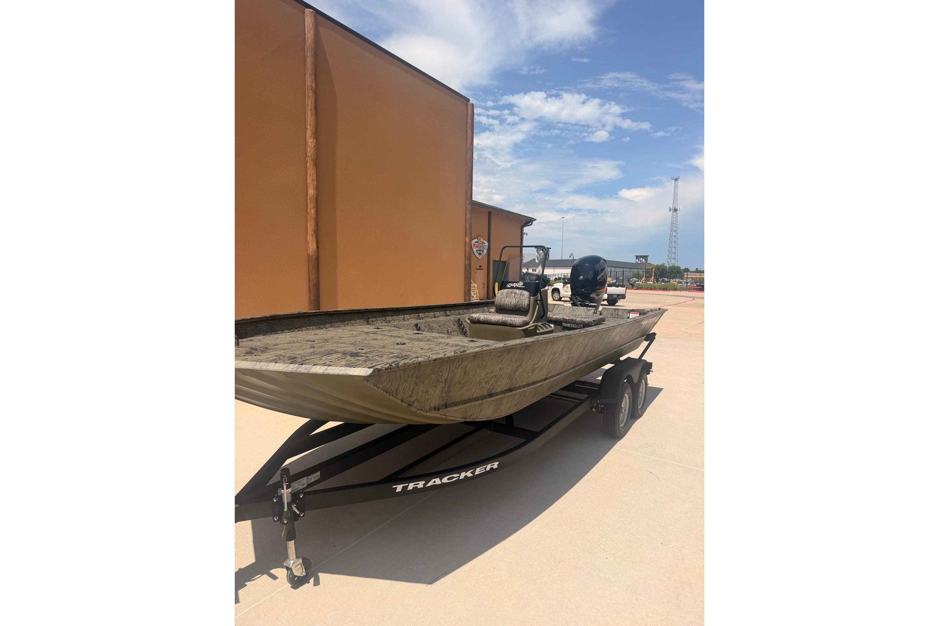 2026 Tracker Grizzly 2072 CC boat on trailer, parked outdoors under clear sky.