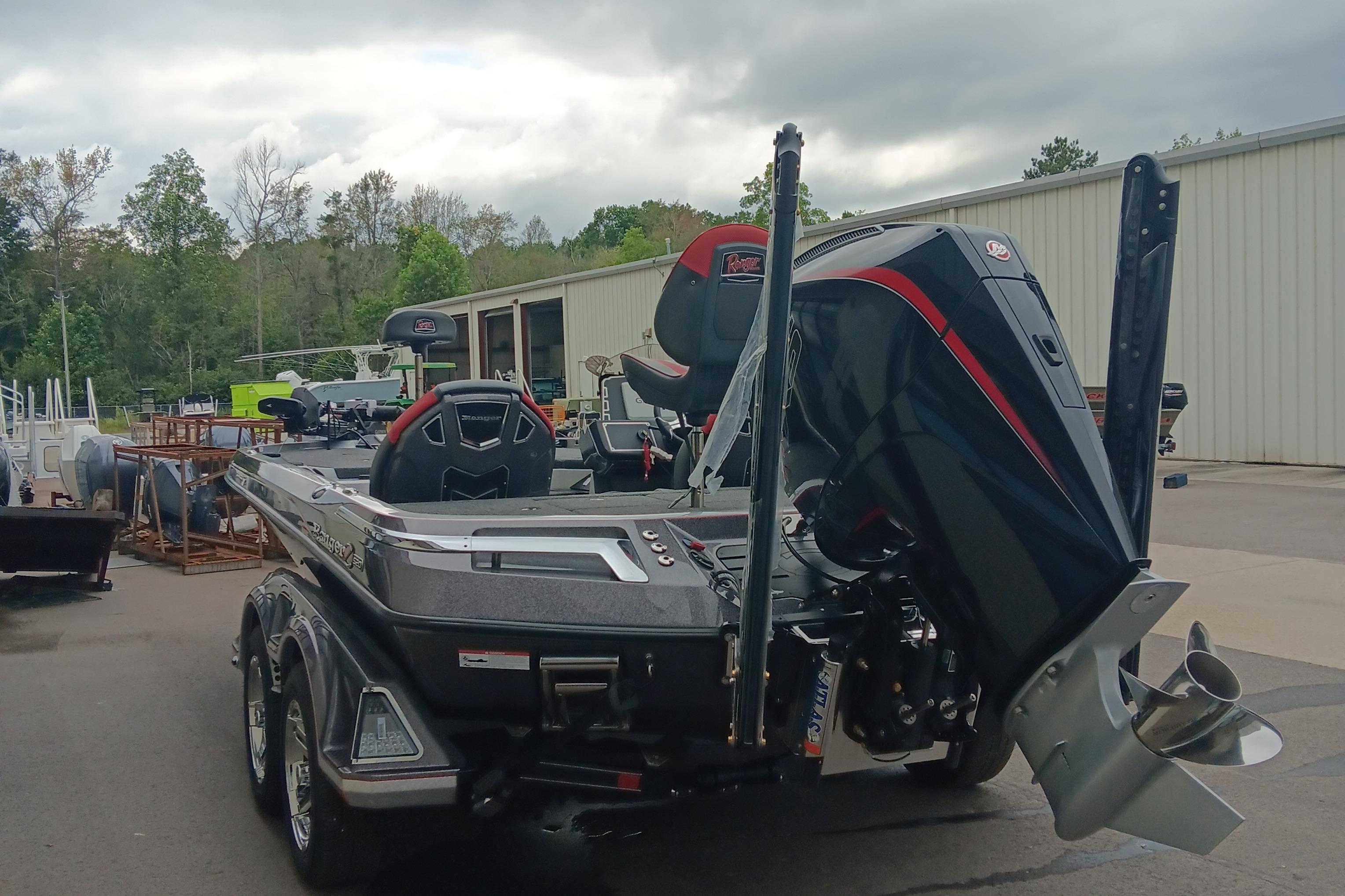 2026 Ranger Z520 boat with powerful outboard motor, parked outdoors near a warehouse.