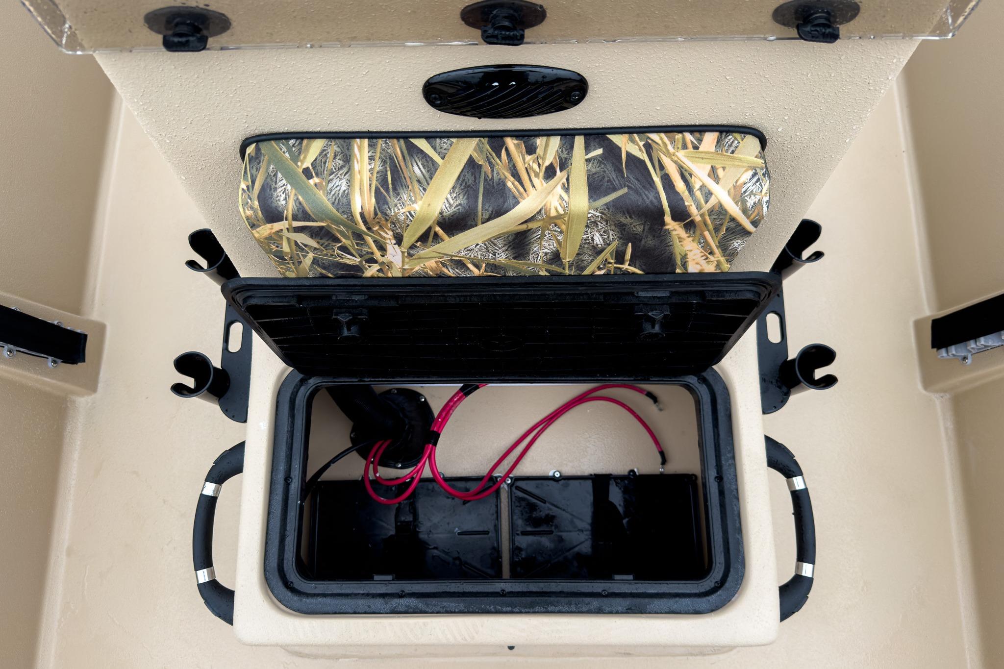 2026 Carolina Skiff E18 JVX CC Sportsman boat storage compartment with camo lid and wiring.