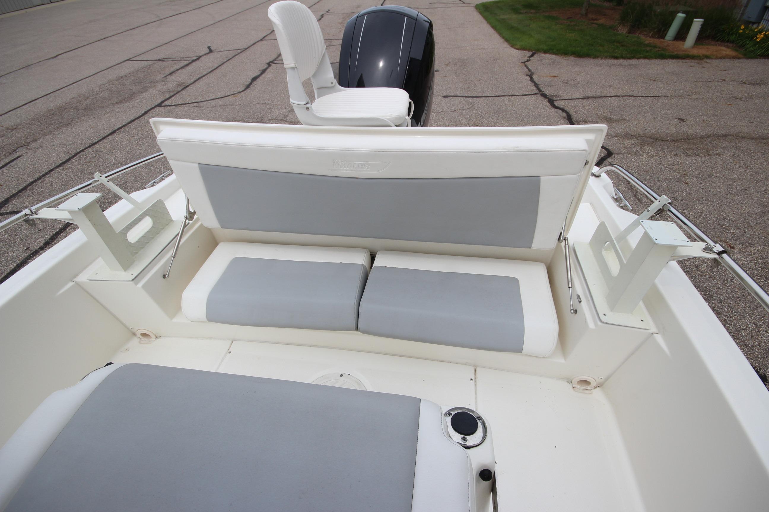 2014 Boston Whaler 210 Dauntless boat interior with cushioned seating and motor view.