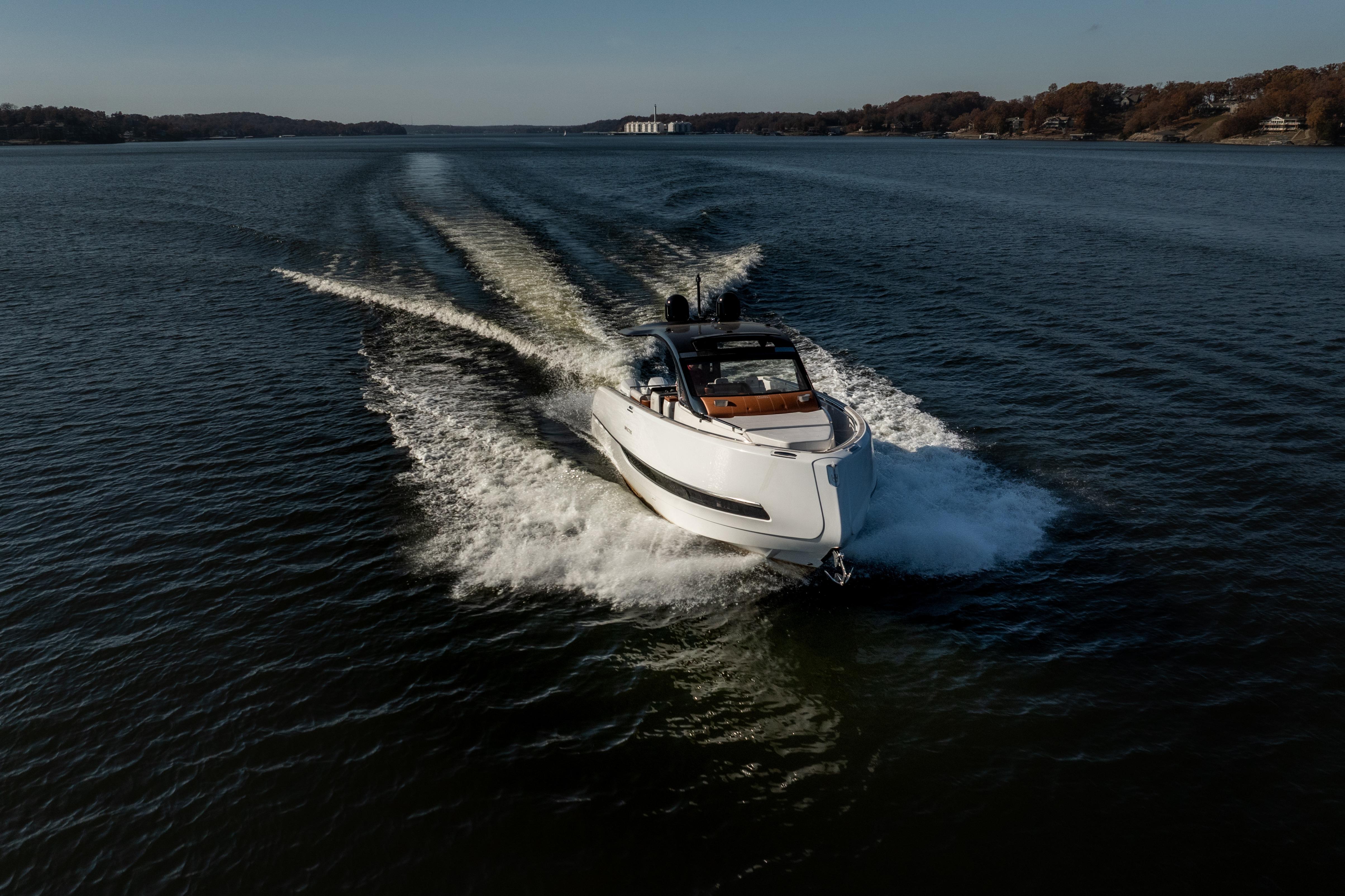 2025 Invictus TT430 yacht cruising on a serene lake under clear skies.