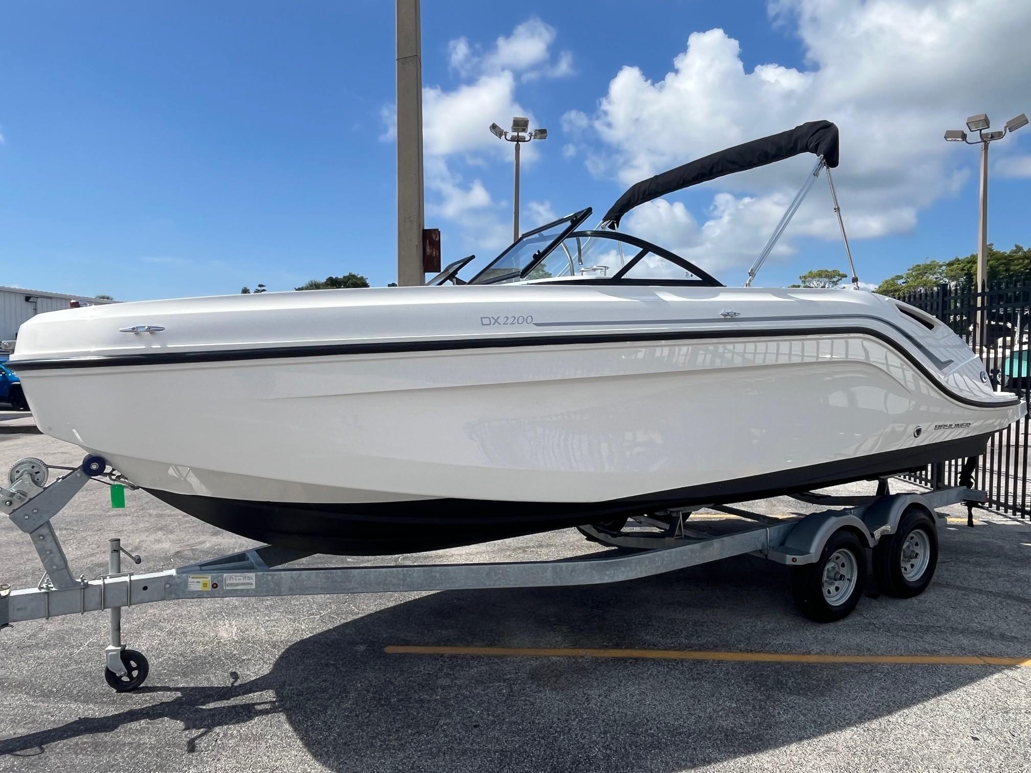 2022 Bayliner DX 2200 boat on trailer under clear blue sky.
