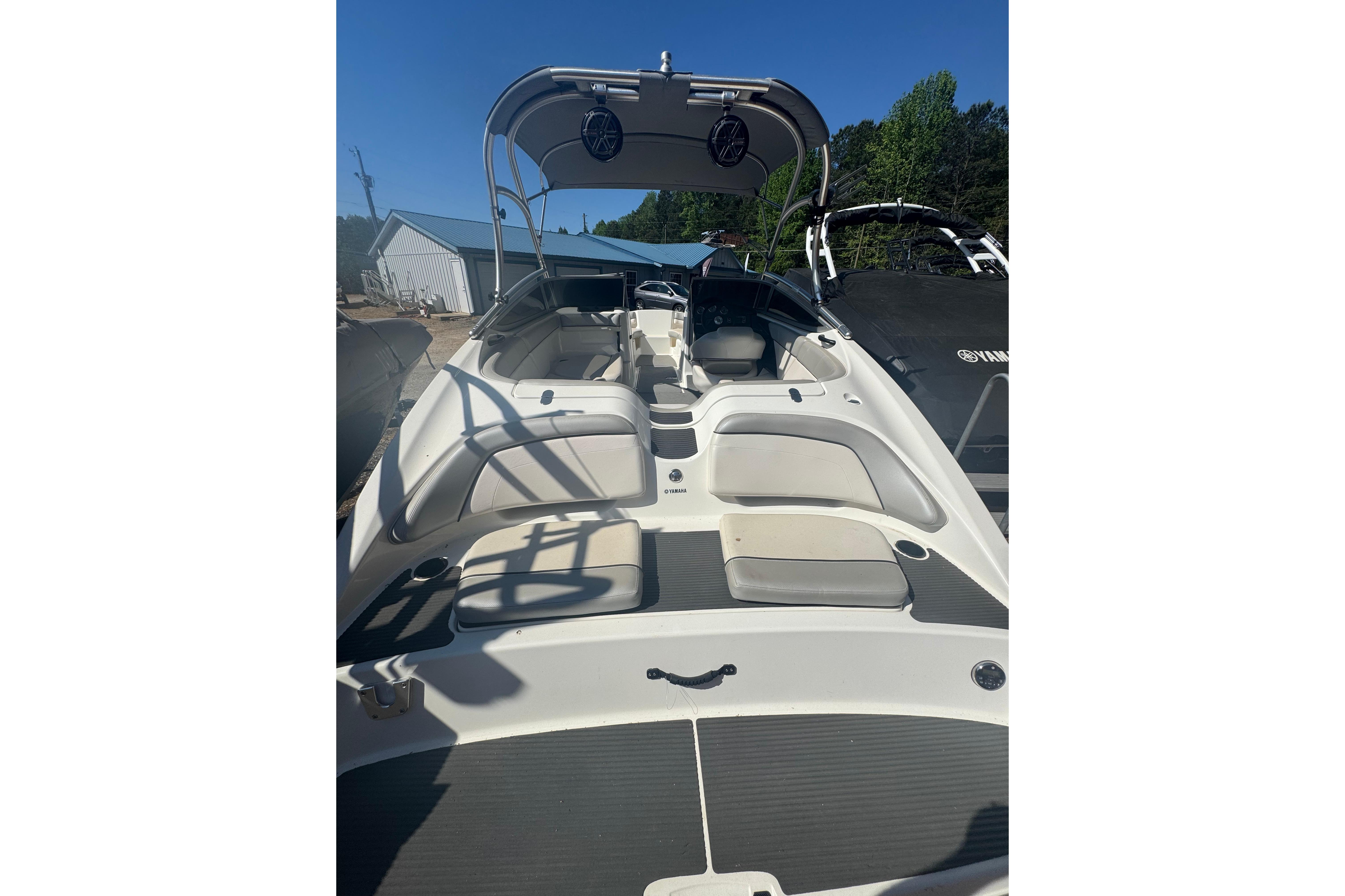 2012 Yamaha Boats AR210 interior with seating and canopy, docked outdoors.