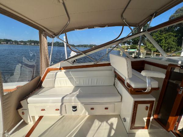 The image shows the cockpit of a 1985 Viking 35 Express with white seating and wood accents.