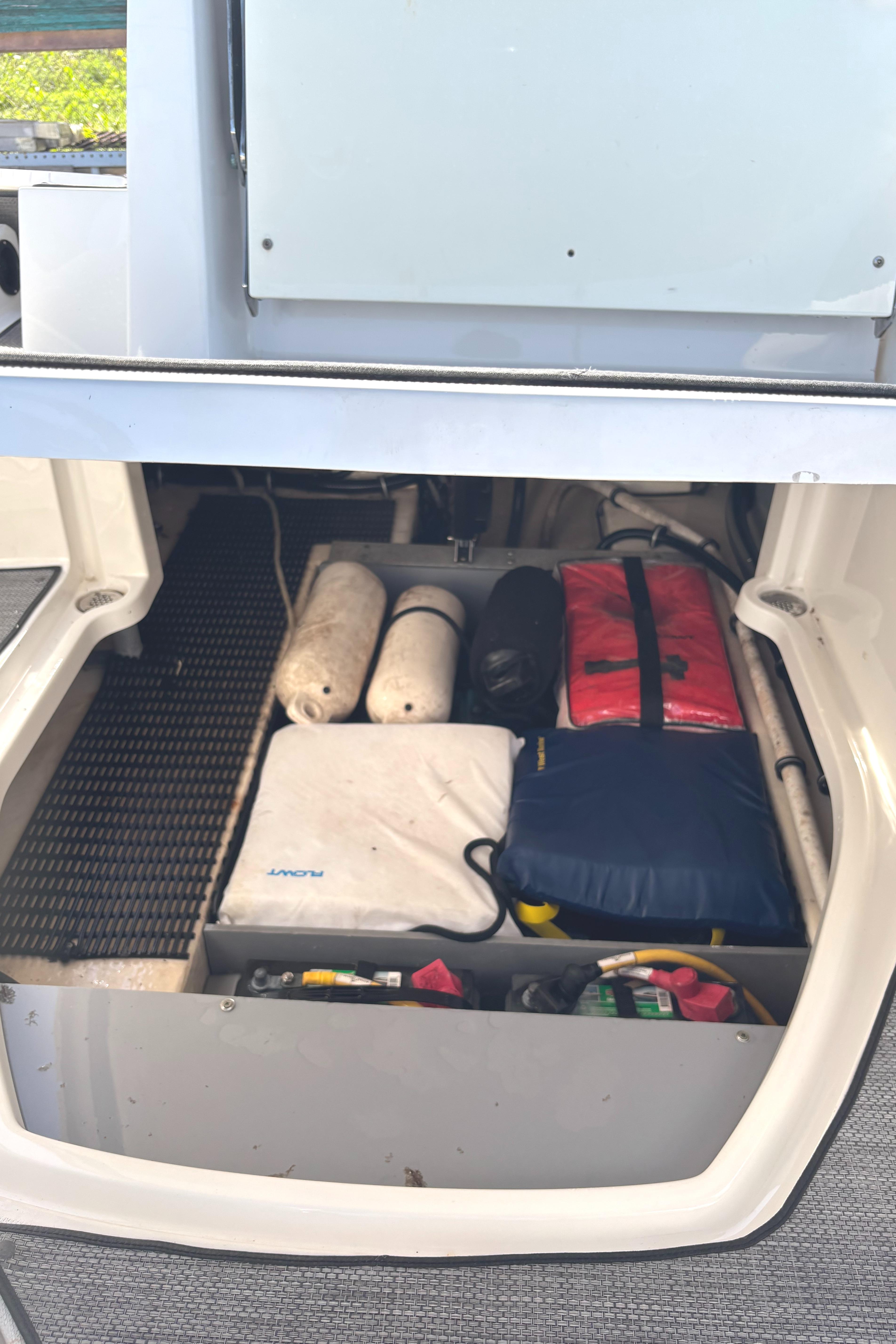 Storage compartment in a 2017 Monterey M65 boat, organized with safety gear and equipment.