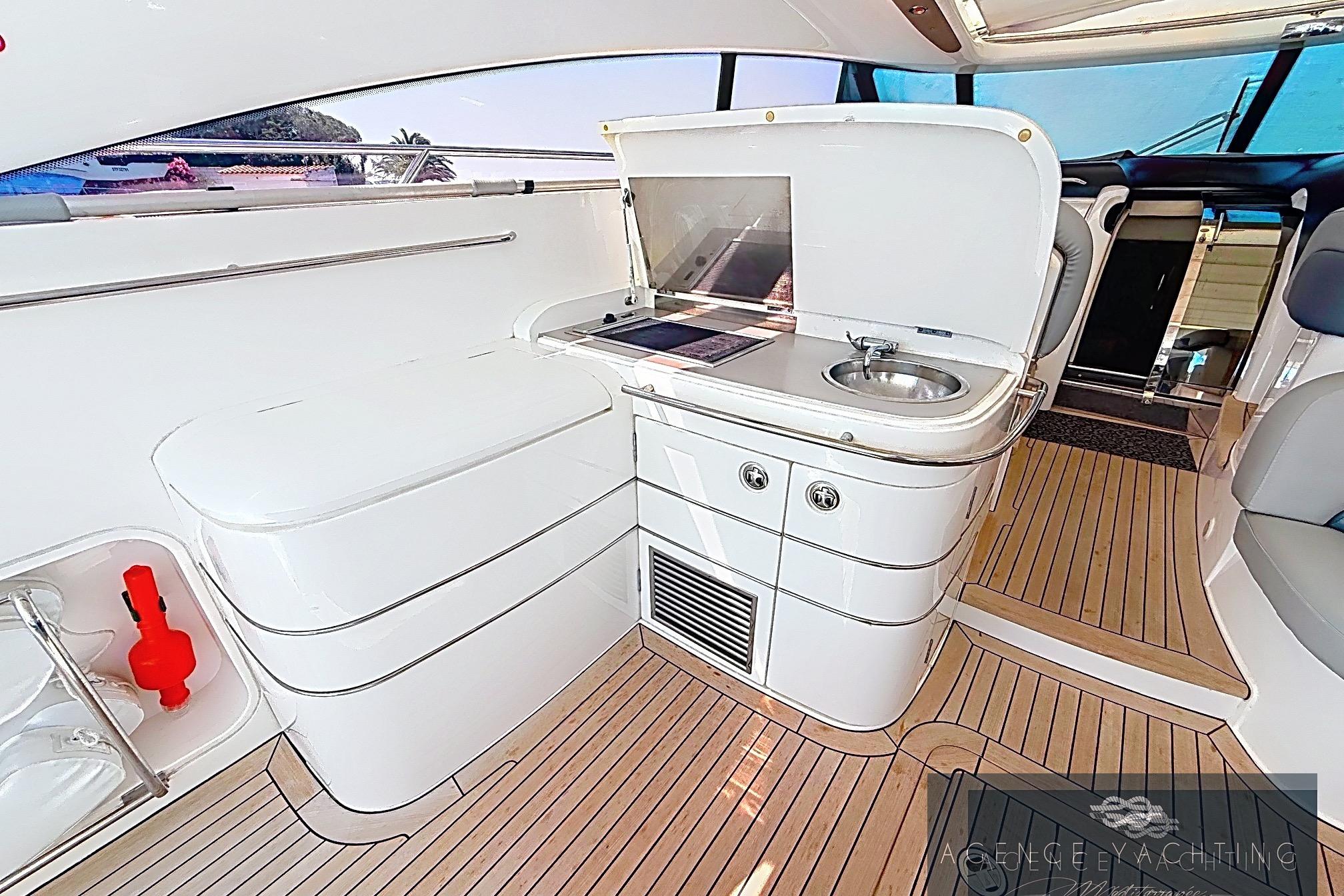 Luxurious 2004 Princess V58 yacht interior with sleek kitchenette and modern design.