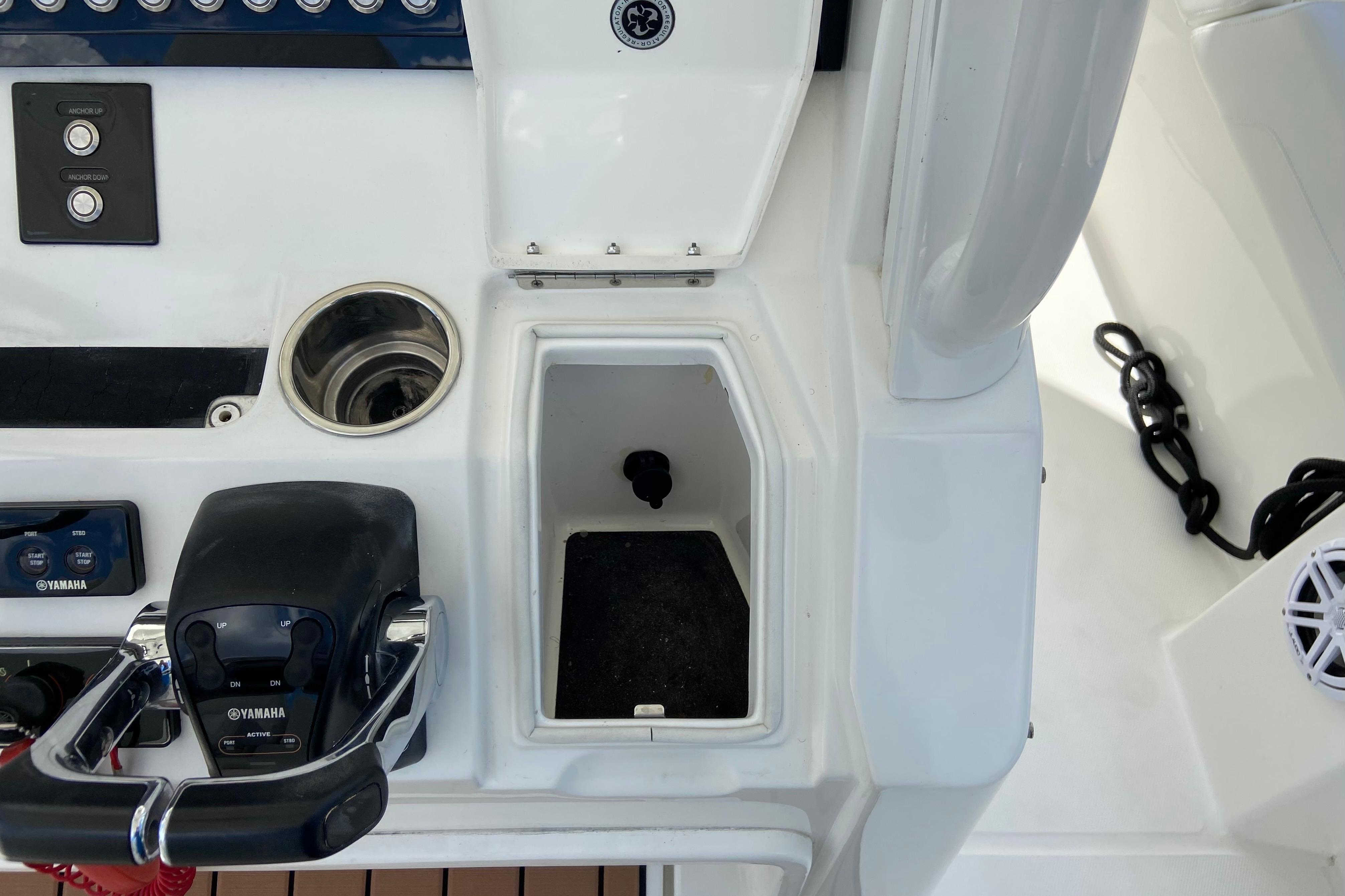 Control panel of a 2021 Regulator 28 boat featuring Yamaha throttle and storage compartment.