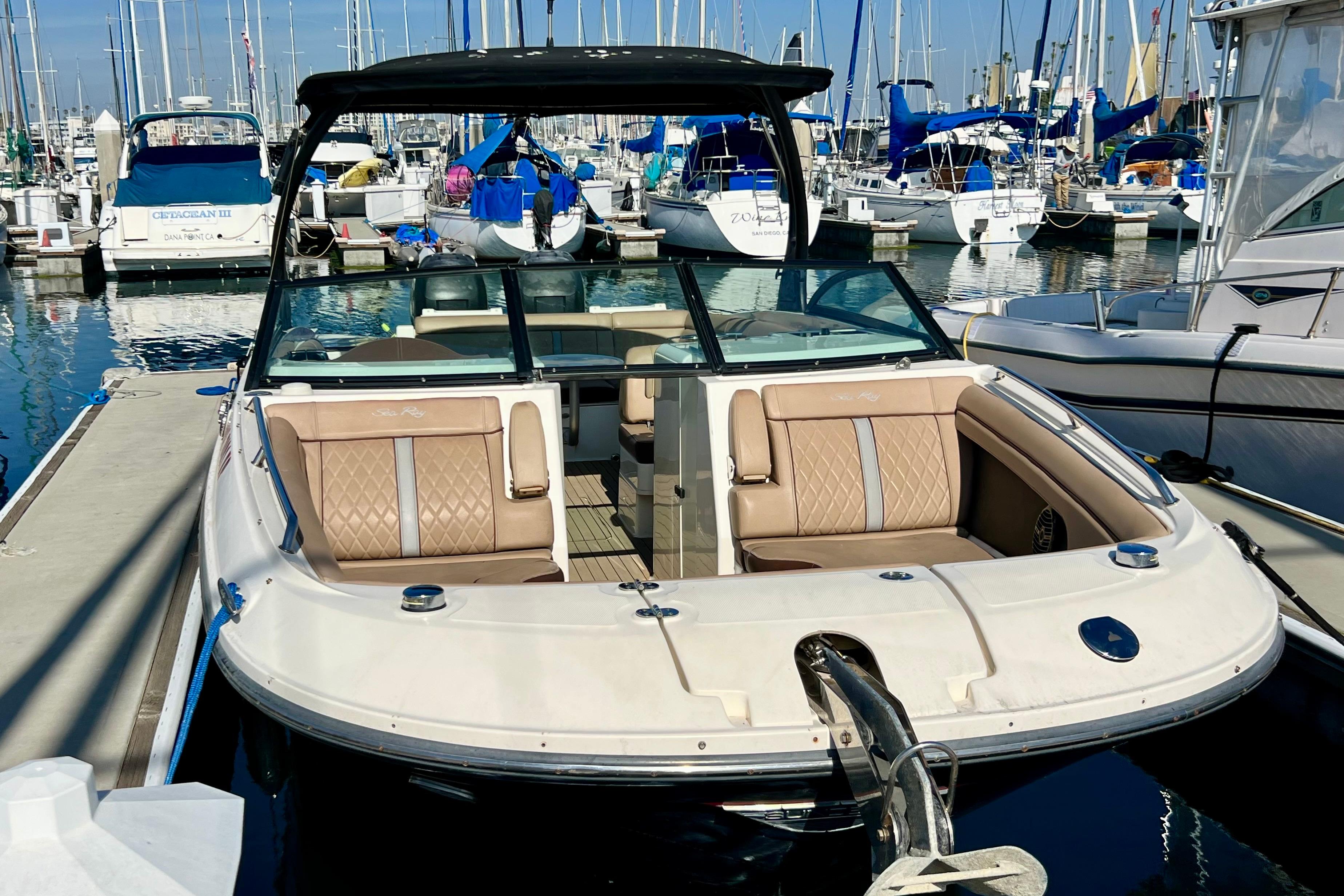 2016 Sea Ray 290 Sundeck Outboard docked at a marina with sailboats.