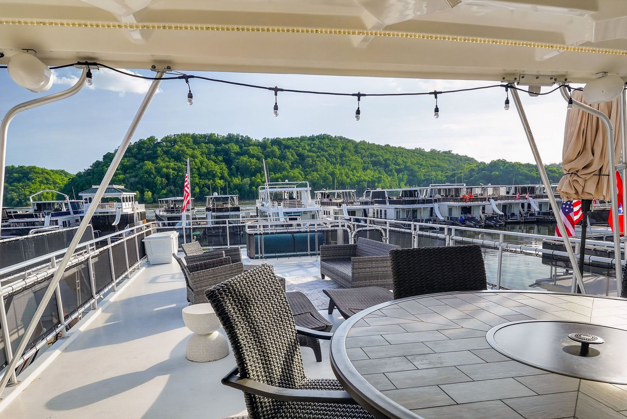 Houseboat deck overlooking marina and wooded hills.