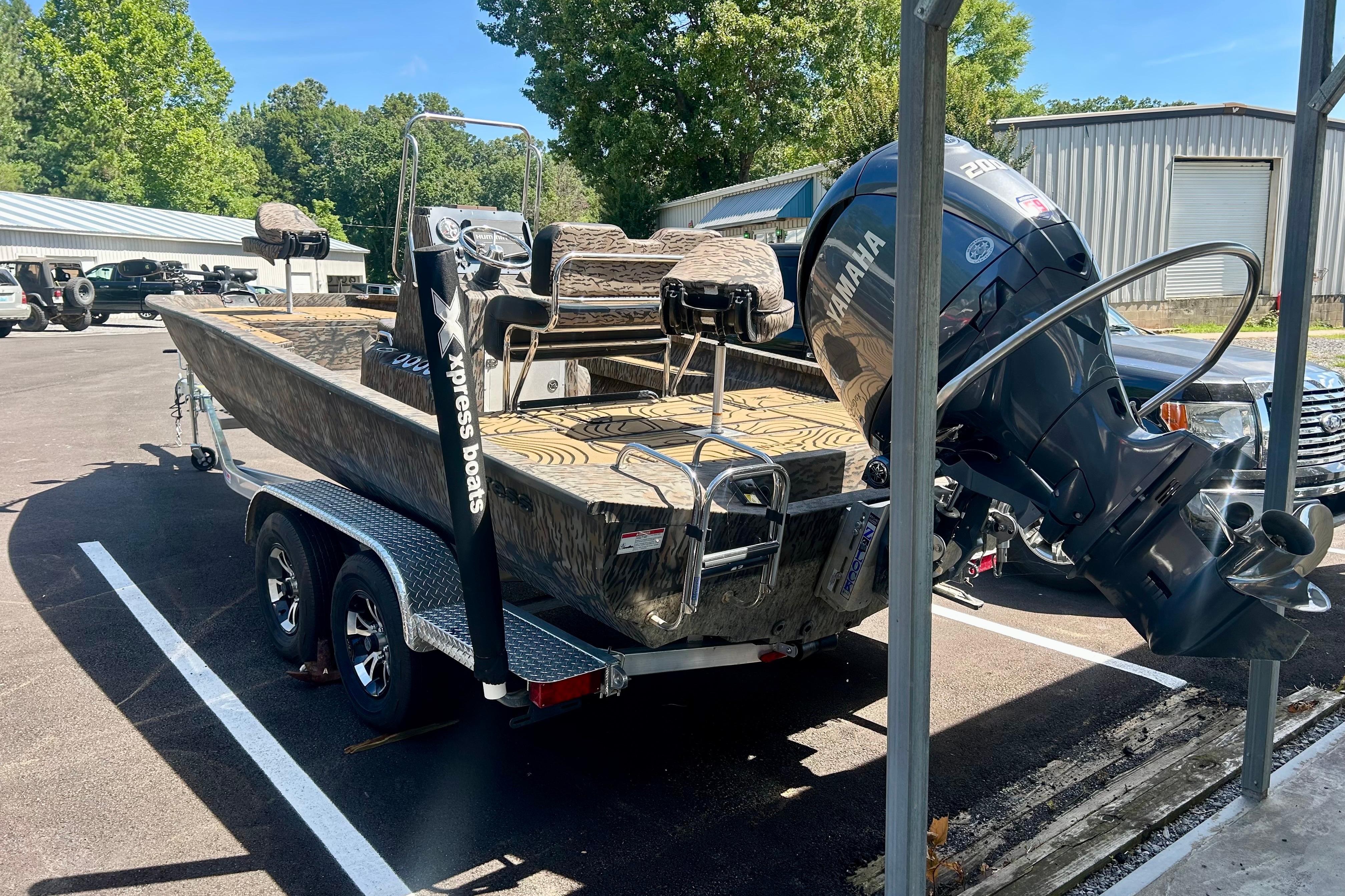 2025 Xpress H22B Bay boat with Yamaha engine on trailer in parking lot.
