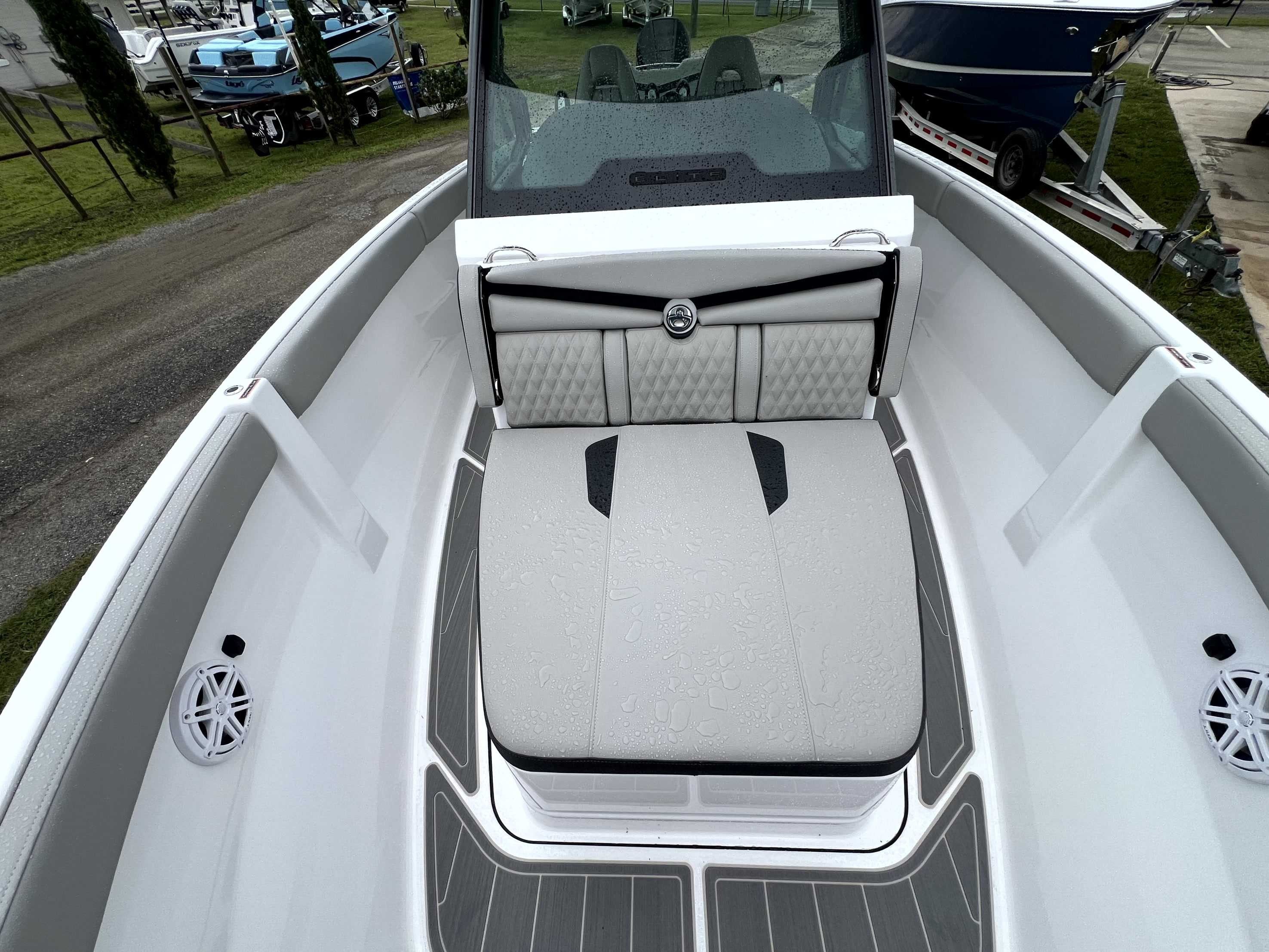 The image shows the cockpit of a Monterey Elite 25 boat with gray upholstery and speakers.