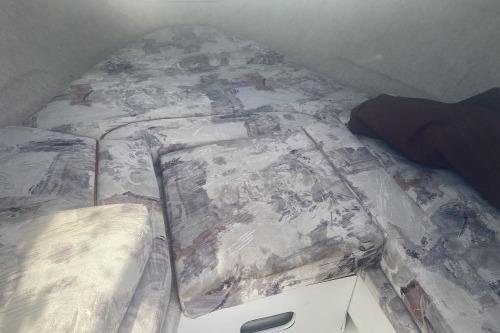 Interior cabin of a 1997 Sea Ray 230 Overnighter with patterned cushions.