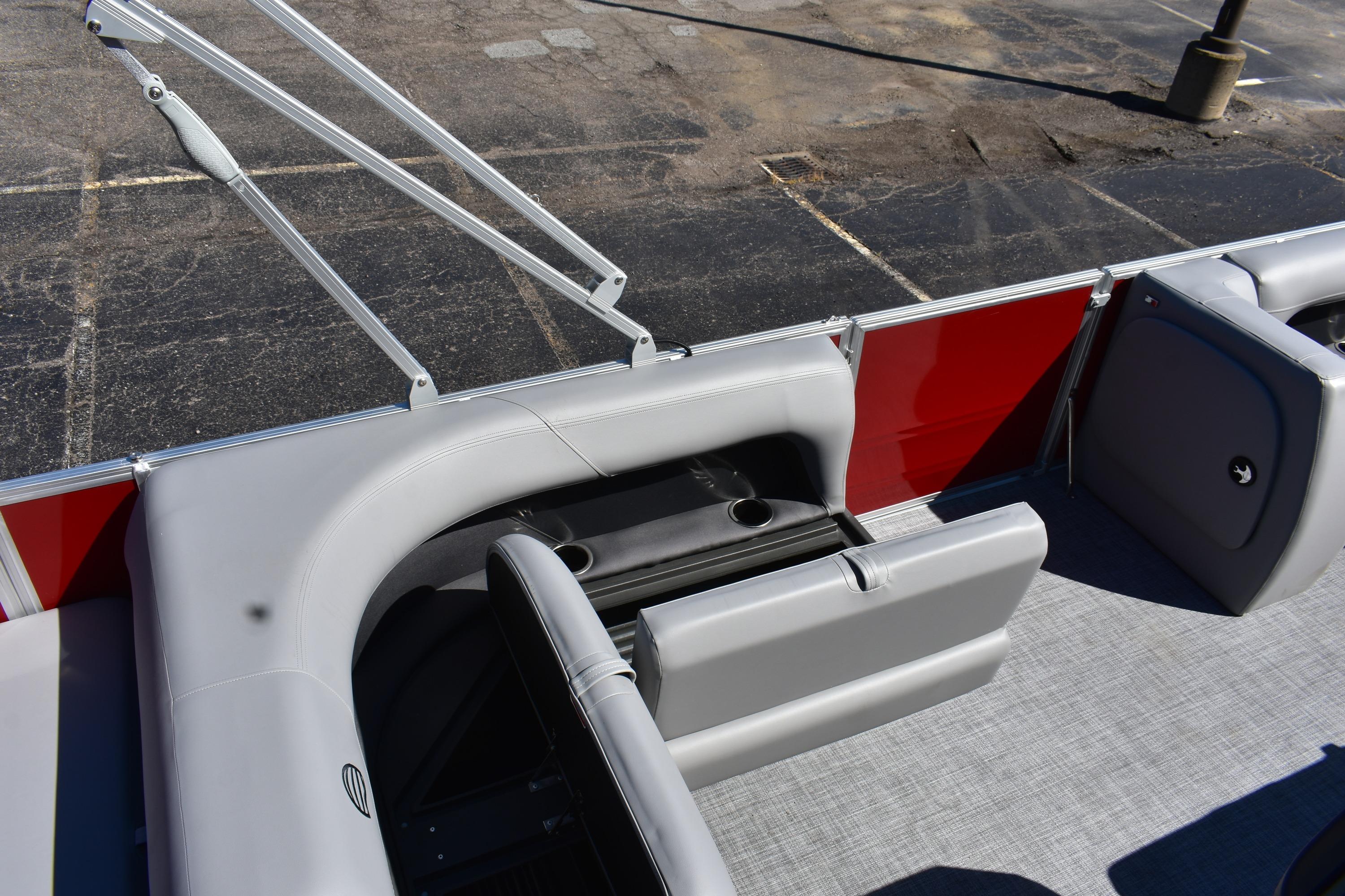 2026 Sun Tracker Party Barge 18 DLX interior with gray seating and red paneling.