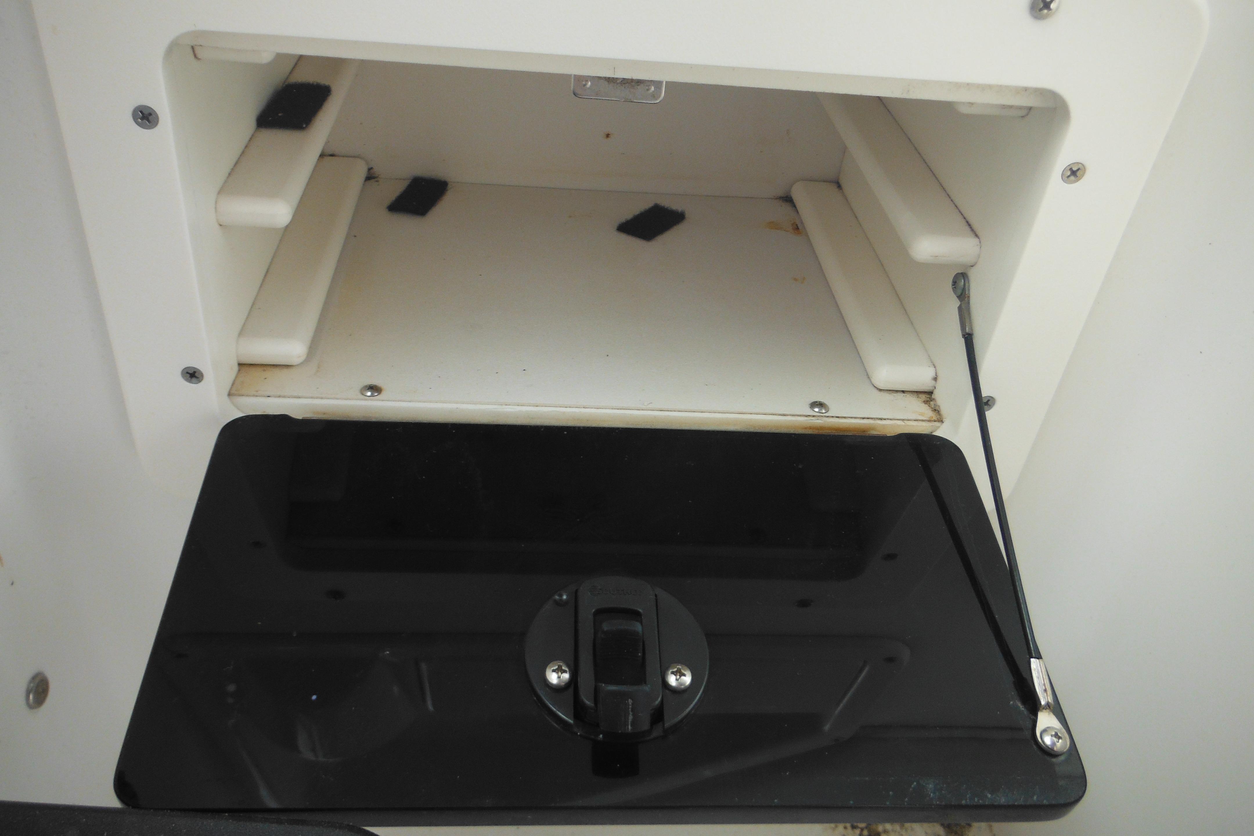 Storage compartment of 2005 Seaswirl Striper 2101 Walkaround O/B boat, open with latch.
