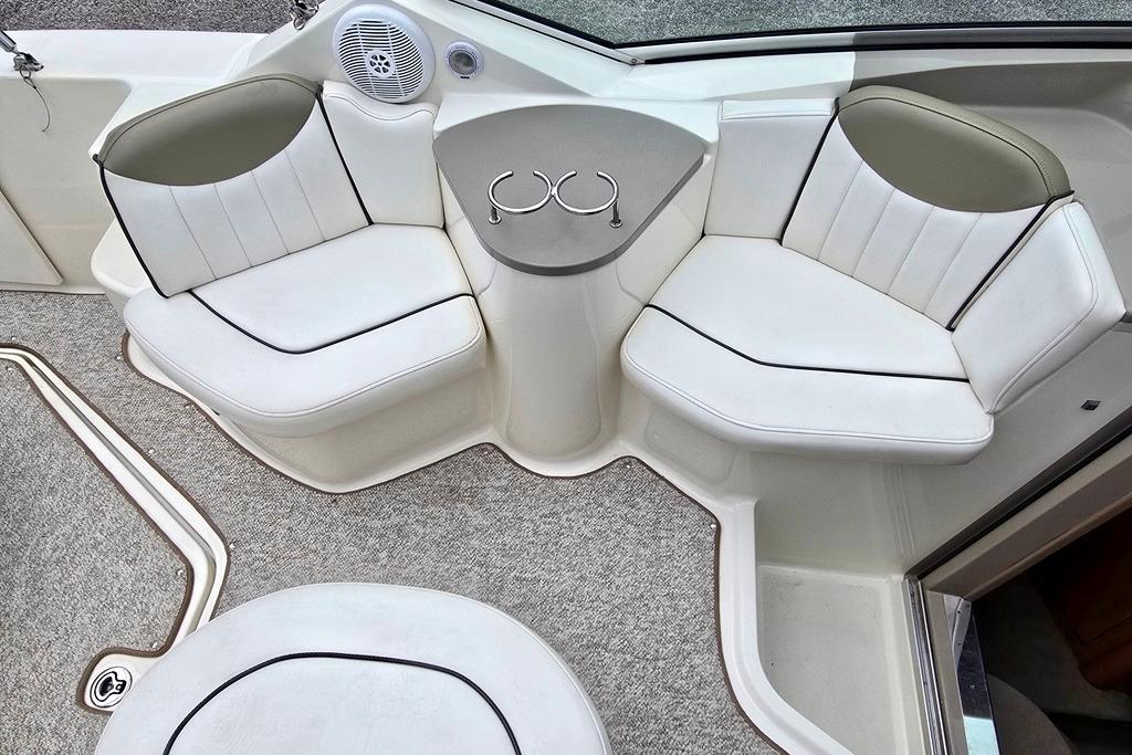 Interior seating of 2006 Sea Ray 240 Sundancer boat with white upholstery.