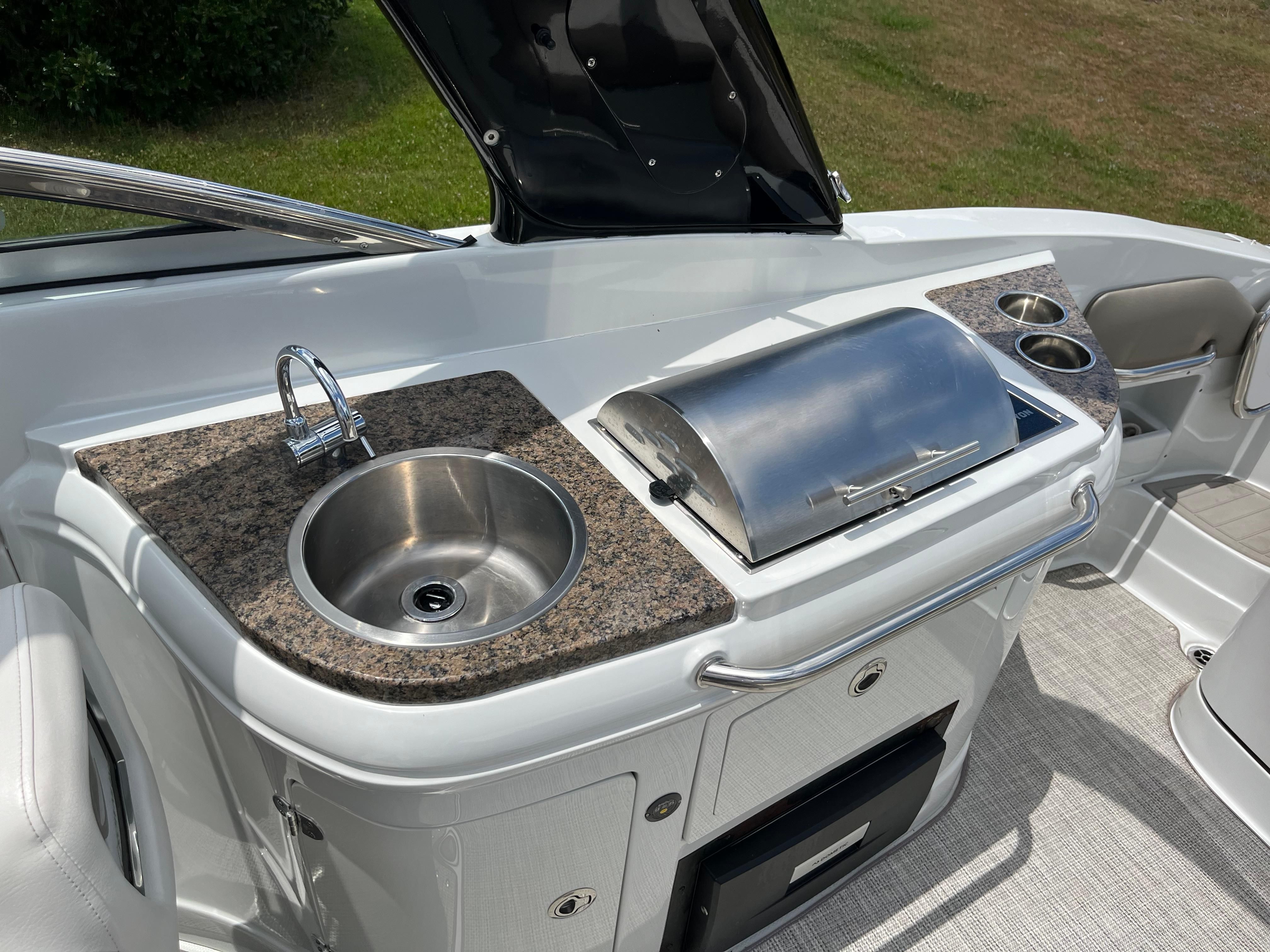 The 2019 Crownline E 285 features an outdoor kitchen with a sink and grill.