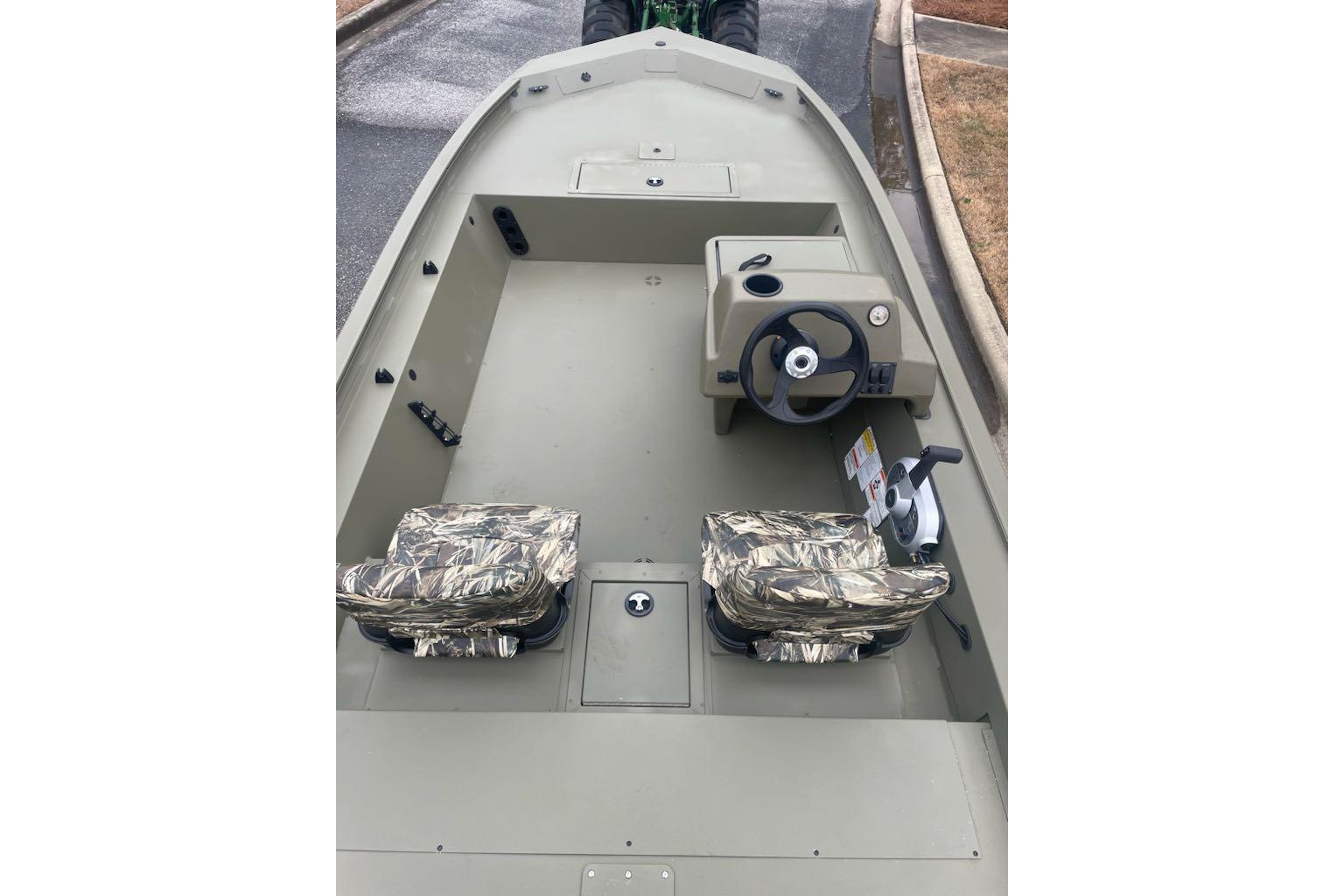 2026 Tracker Grizzly 1754 SC boat interior with camo seats and steering console.