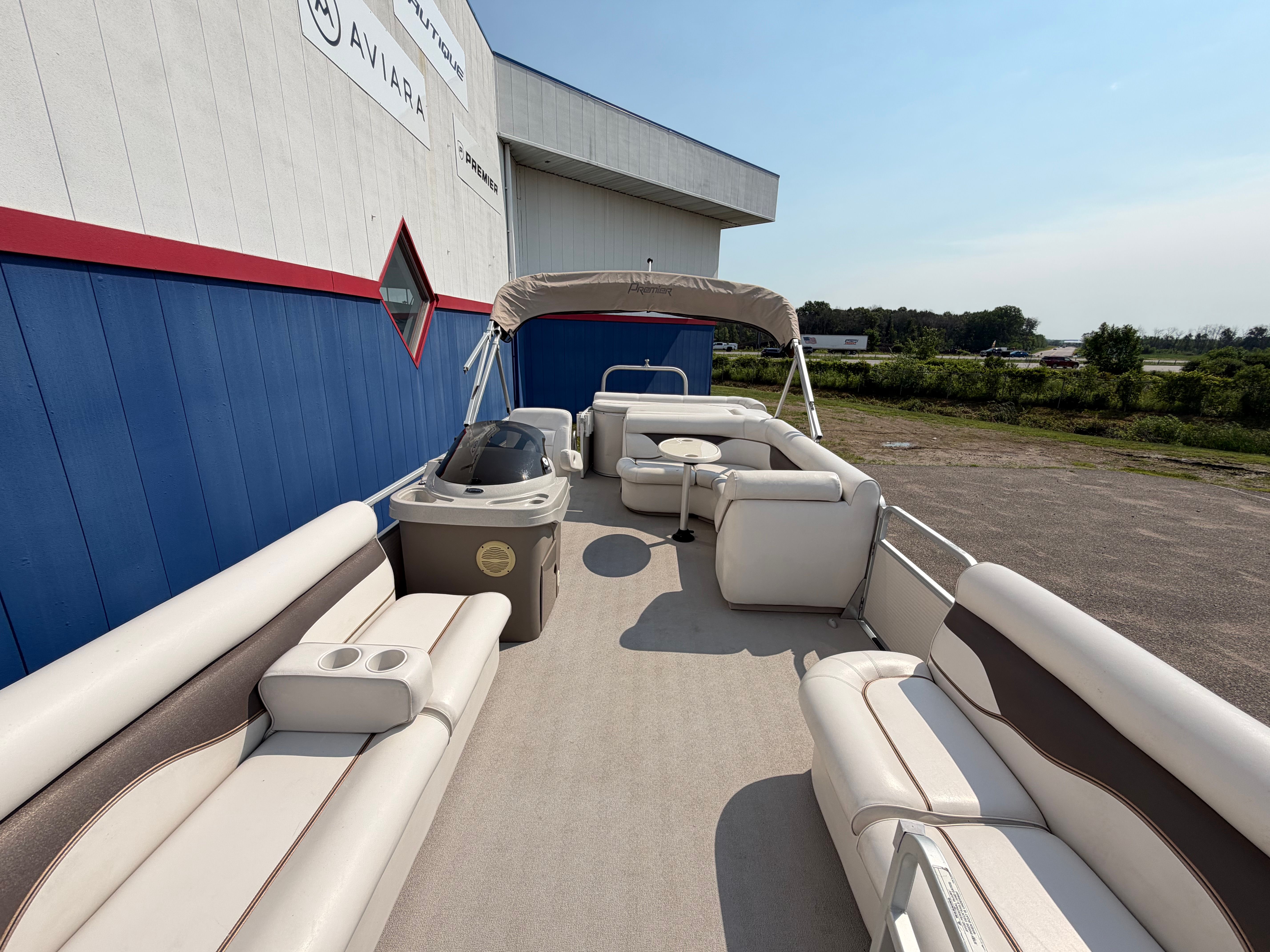 The image shows a 2007 Premier 225 Sunsation pontoon boat with beige seating and a sunshade.