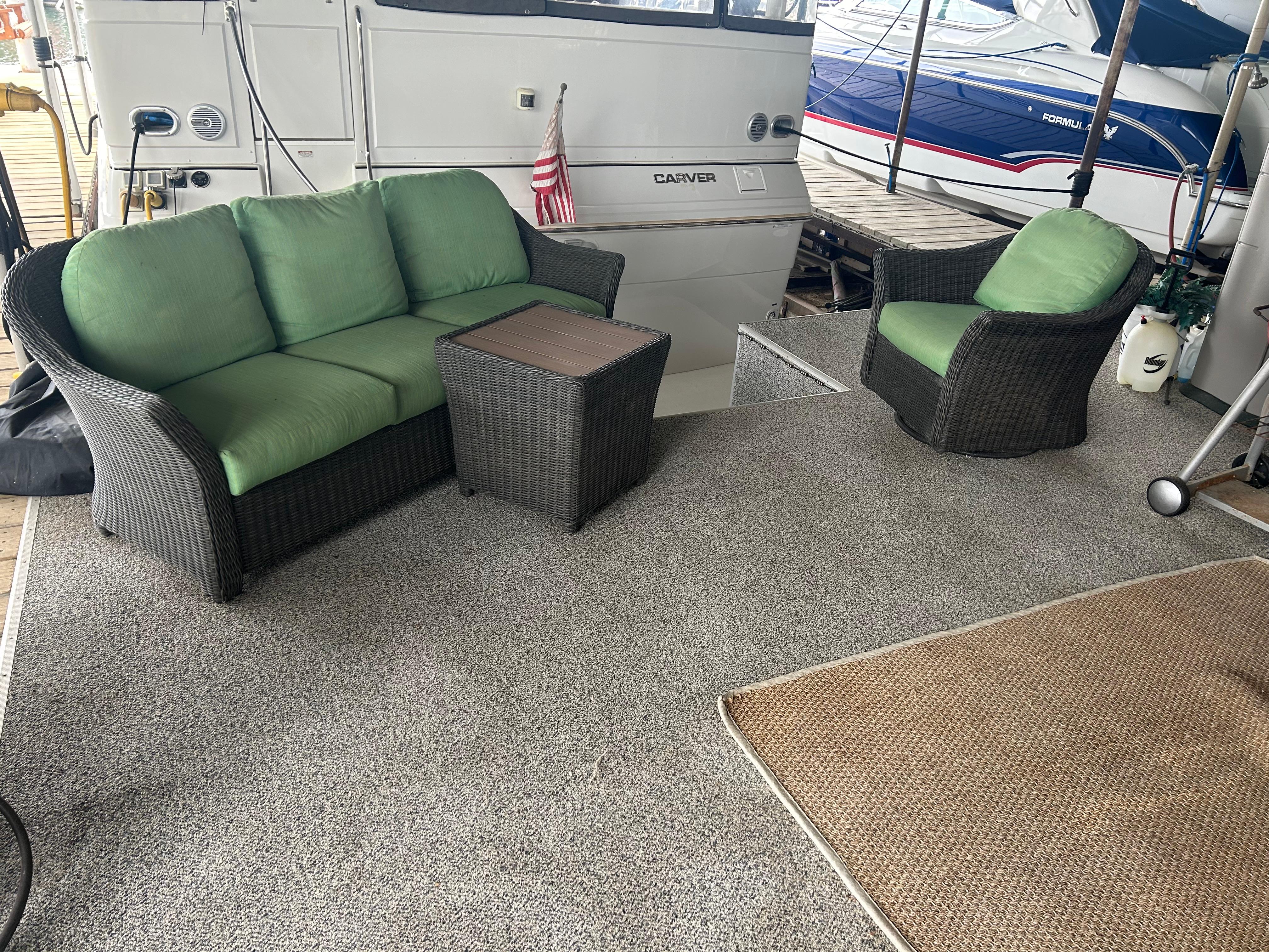 1996 Carver 440 Aft Cabin Motor Yacht with outdoor seating and green cushions.