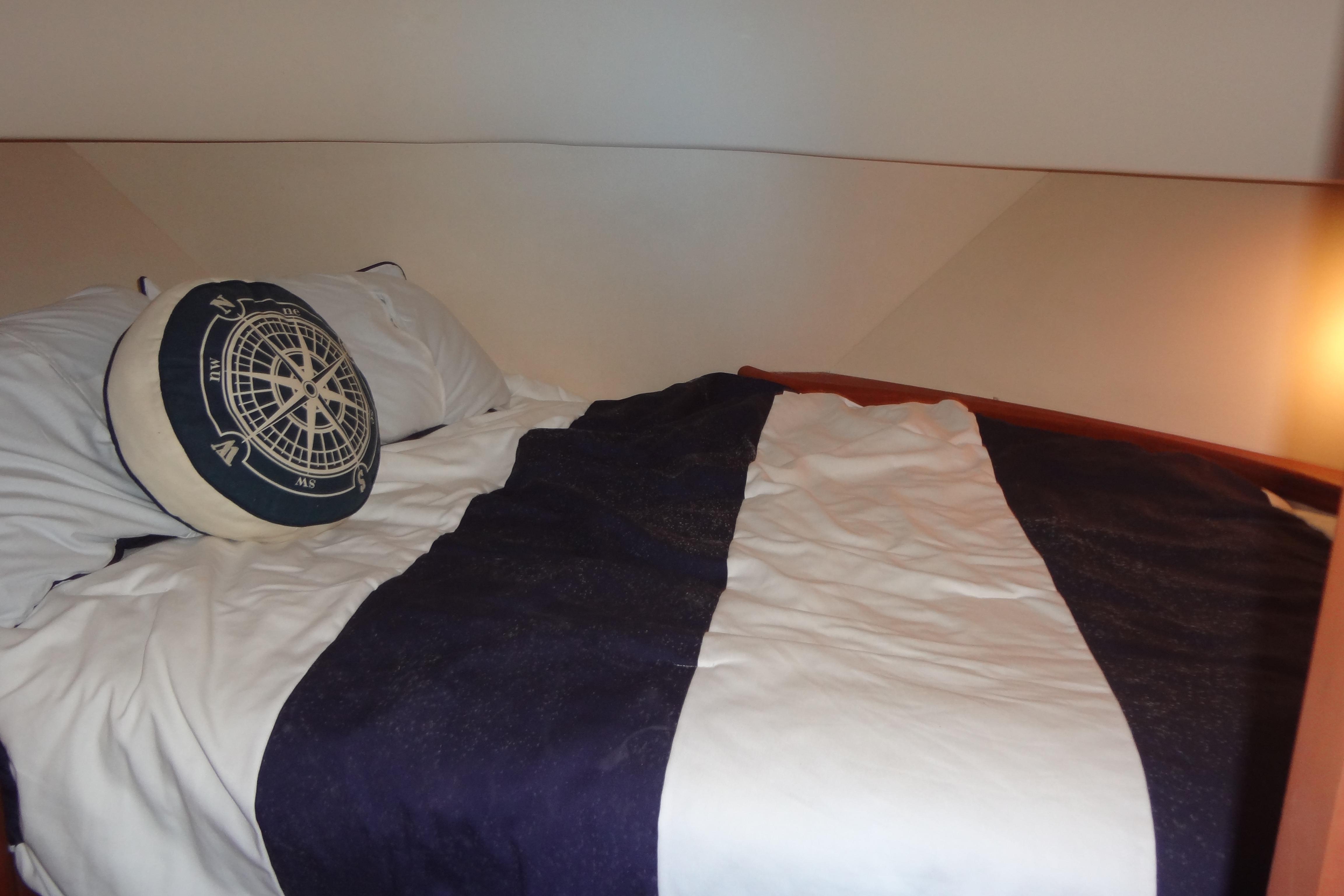 Cozy cabin bed in 2005 Silverton 34 Convertible yacht with nautical-themed pillow.