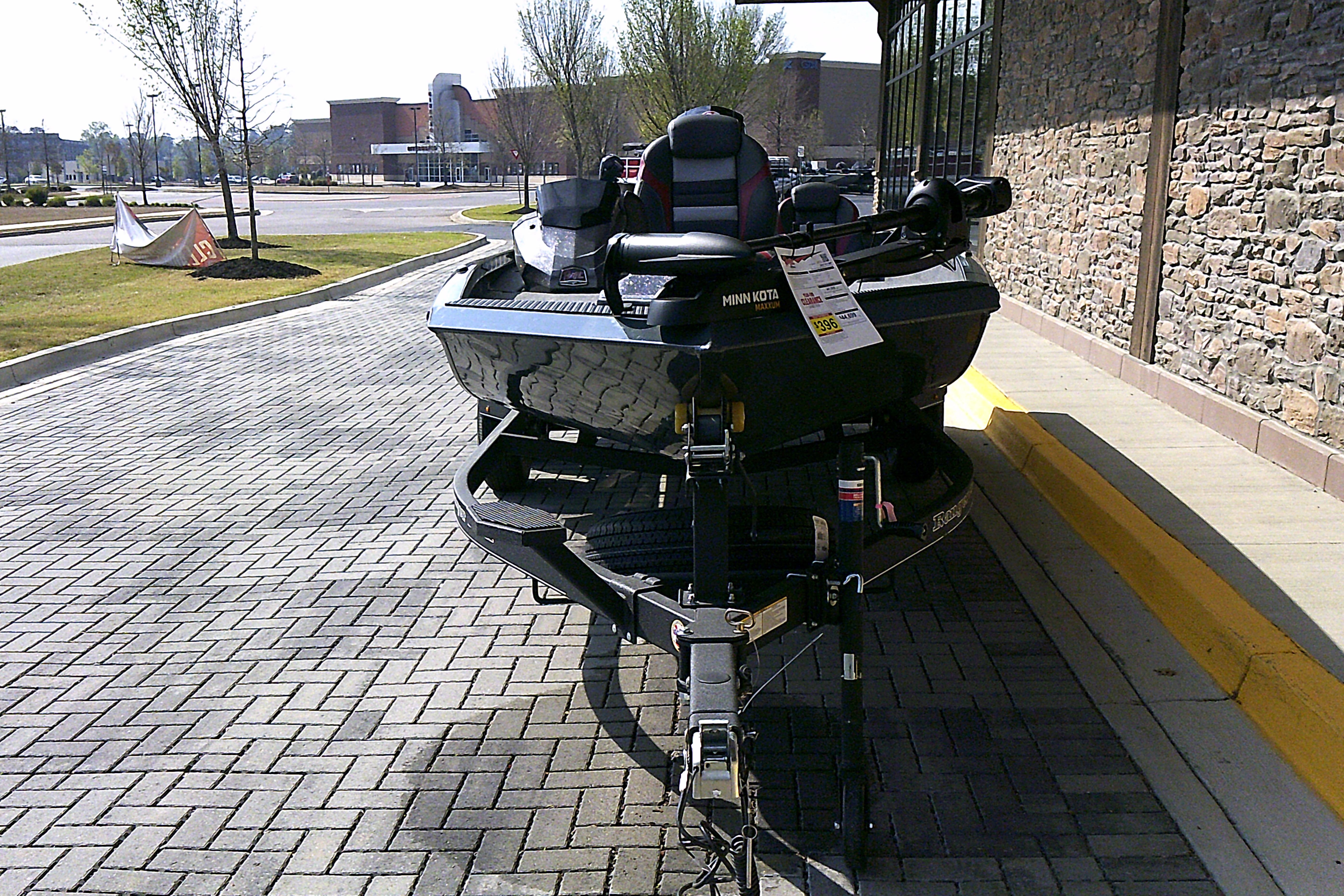 2025 Ranger RT198P boat parked on a paved driveway near a stone wall.