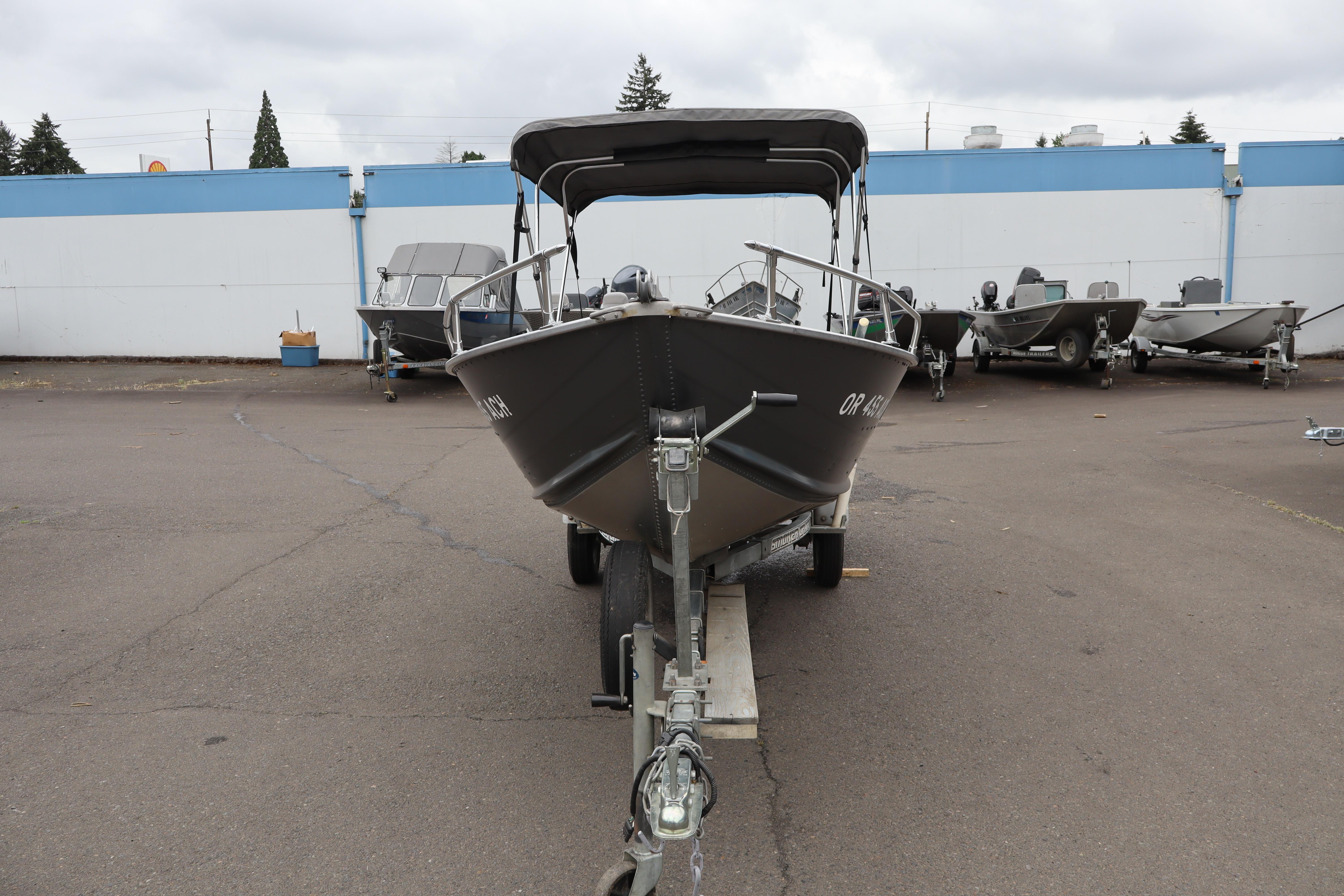 2006 Smoker Craft Alaskan 15 boat on trailer in parking lot.