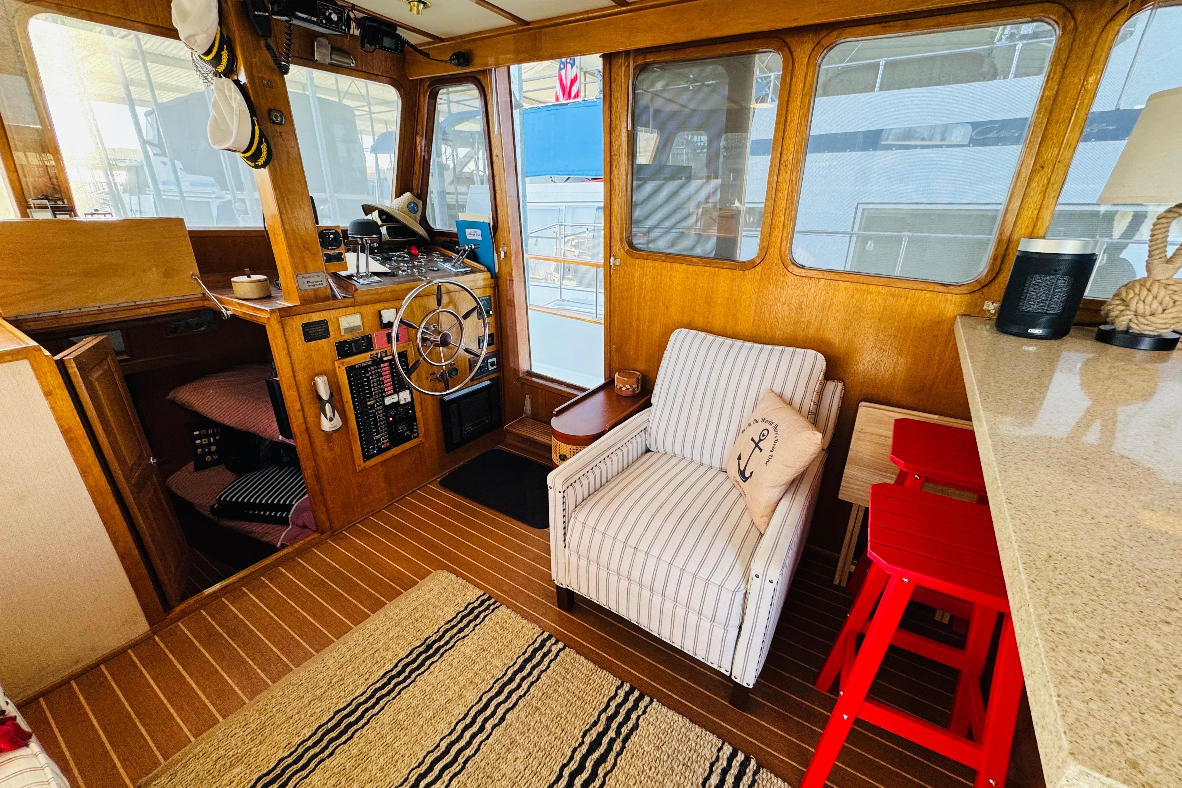 Interior of a 1978 Californian 42 LRC yacht with wooden helm and cozy seating.