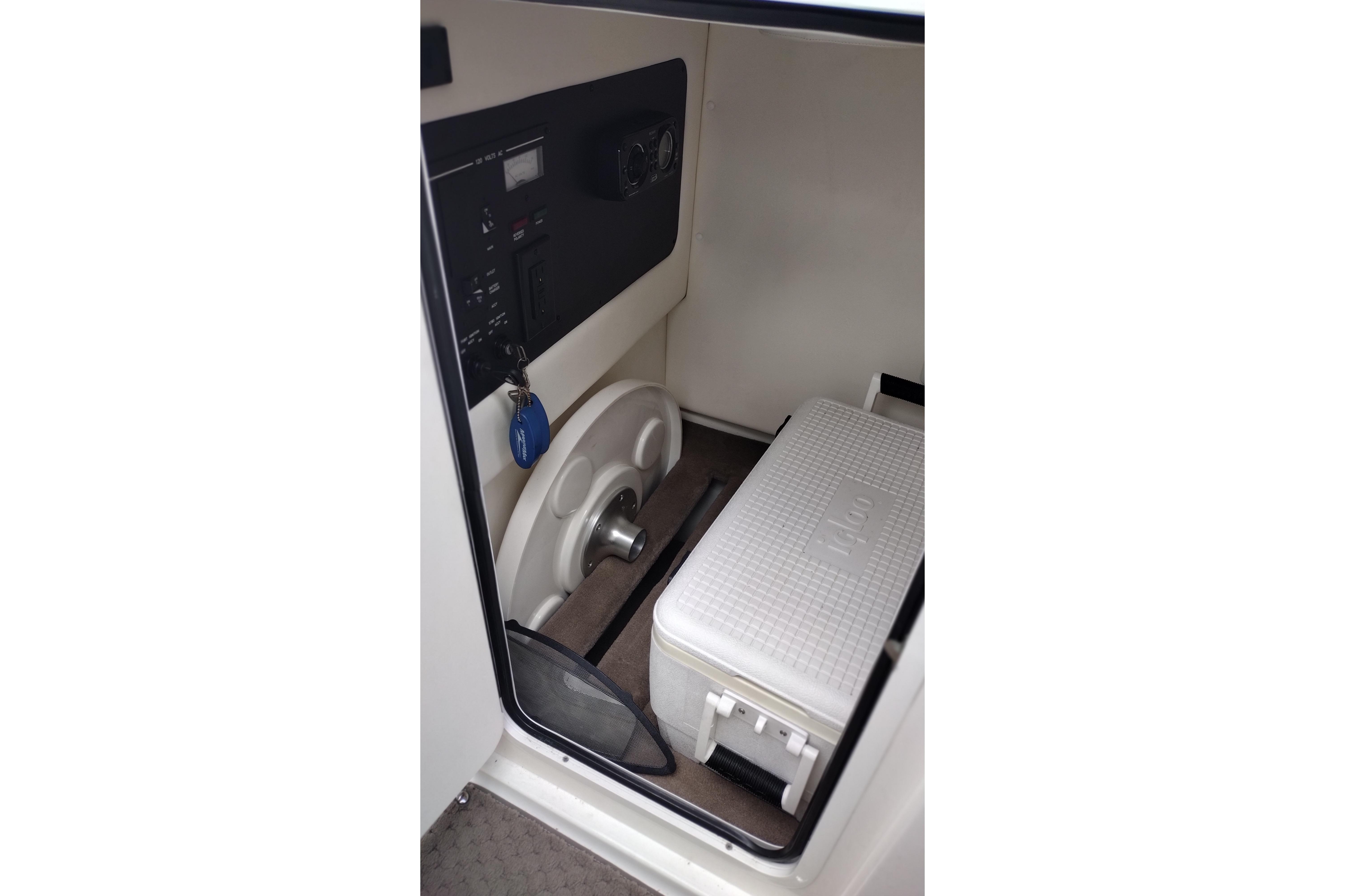 Interior of 2013 Sea Ray 300 SLX boat with control panel and cooler.