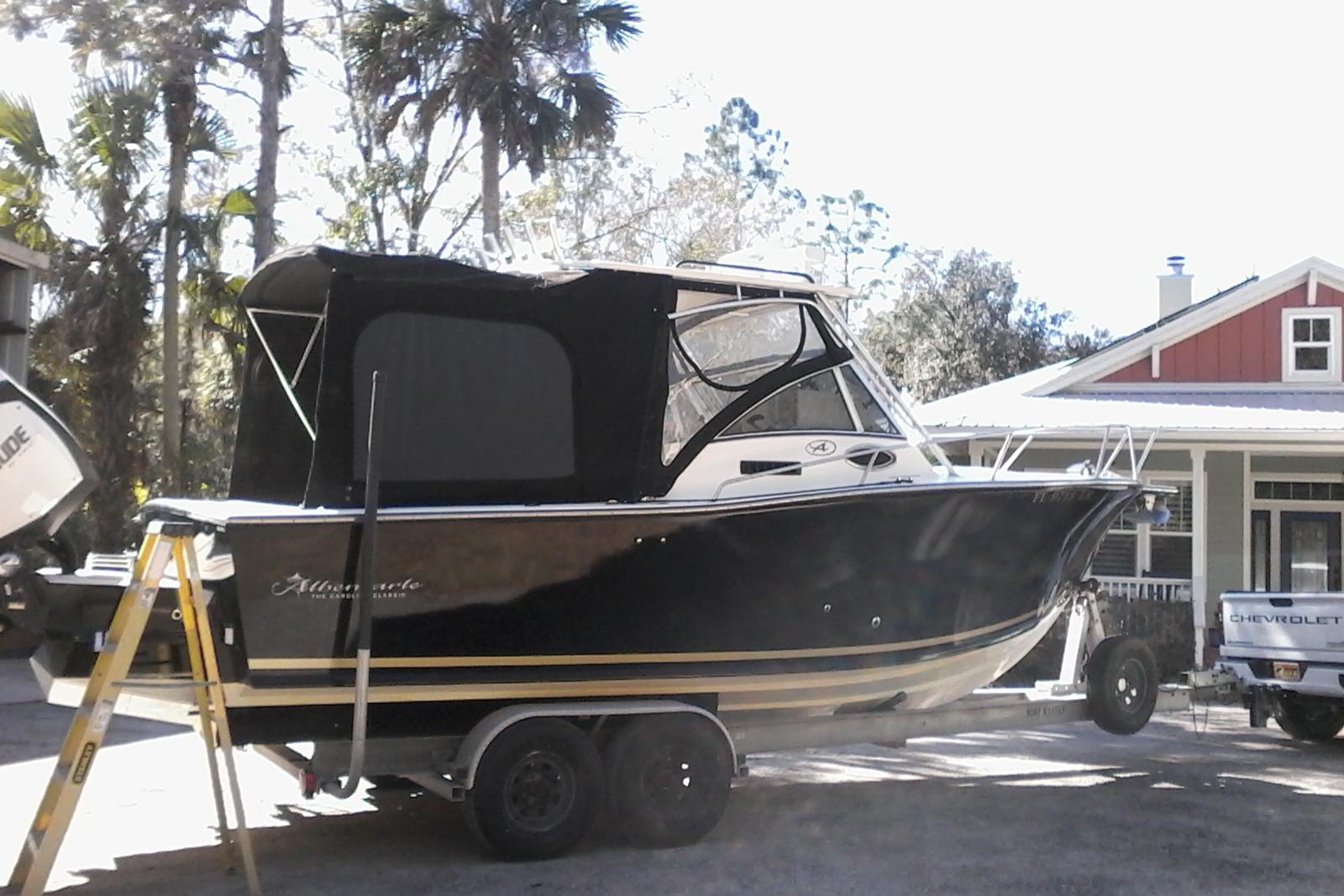 2002 Albemarle 265 Express Fisherman boat on trailer, parked near a house with trees.