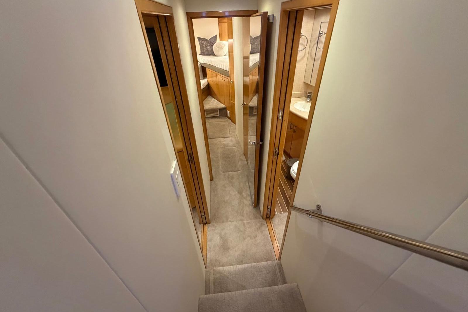 Stairway leading to cozy cabin and bathroom in 2003 Hatteras 54 Convertible yacht.